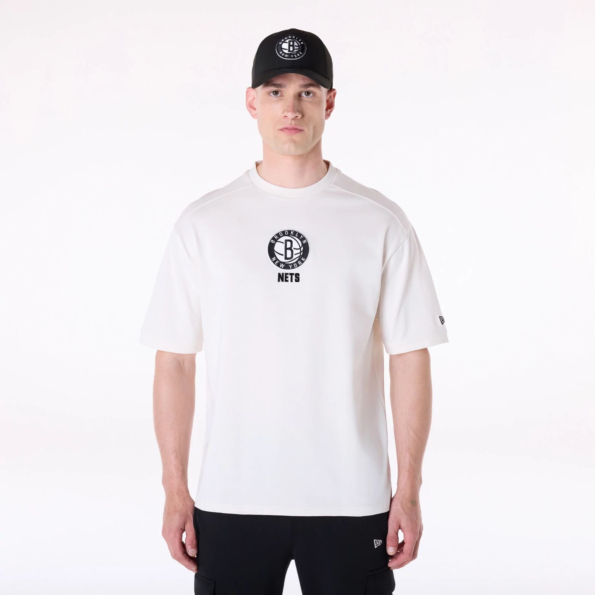 The Male model is wearing Brooklyn Nets NBA Wordmark Open White Oversized T-Shirt 1