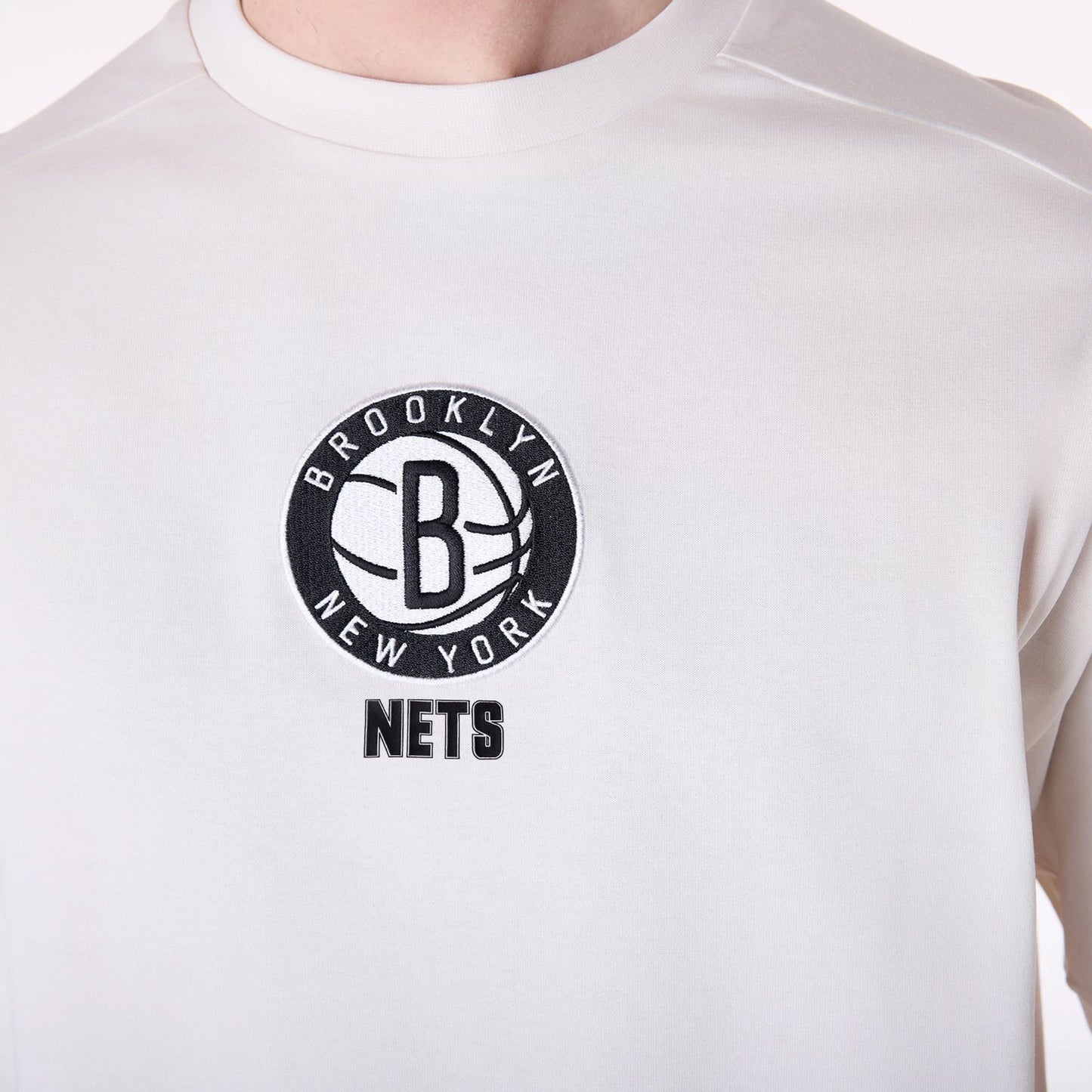 The Male model is wearing Brooklyn Nets NBA Wordmark Open White Oversized T-Shirt 4