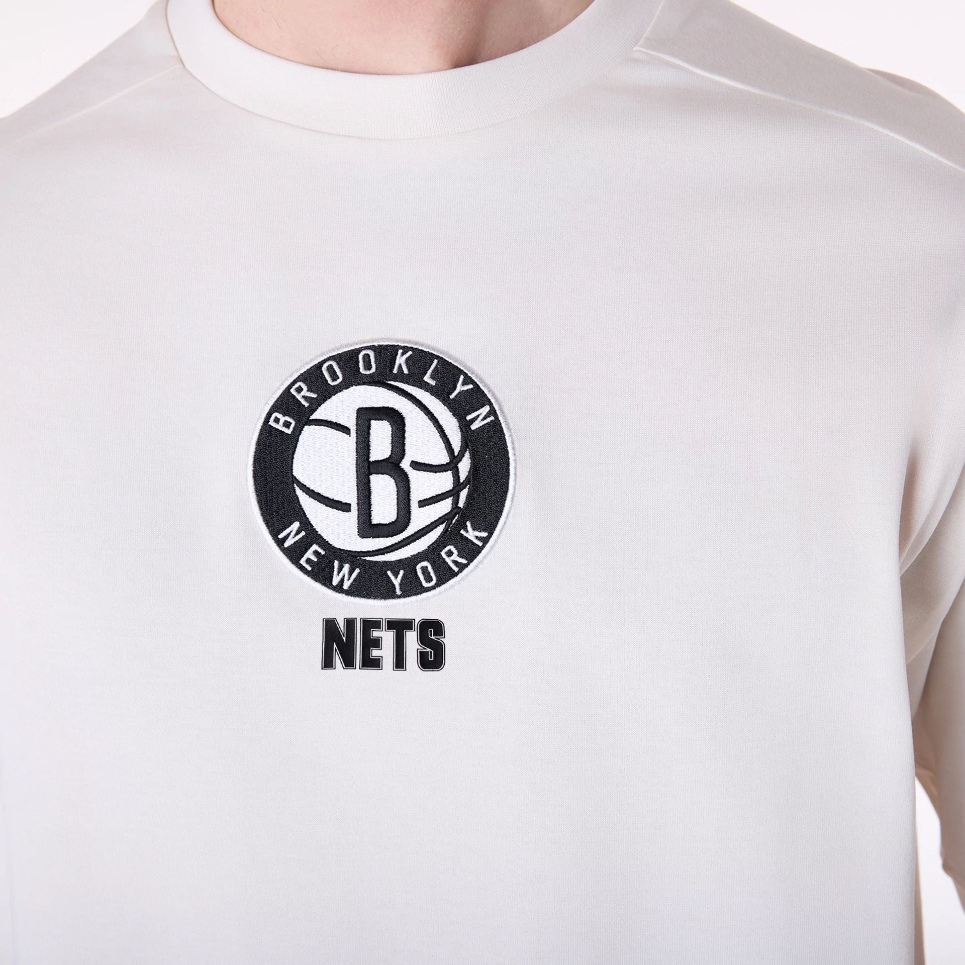 The Male model is wearing Brooklyn Nets NBA Wordmark Open White Oversized T-Shirt 4