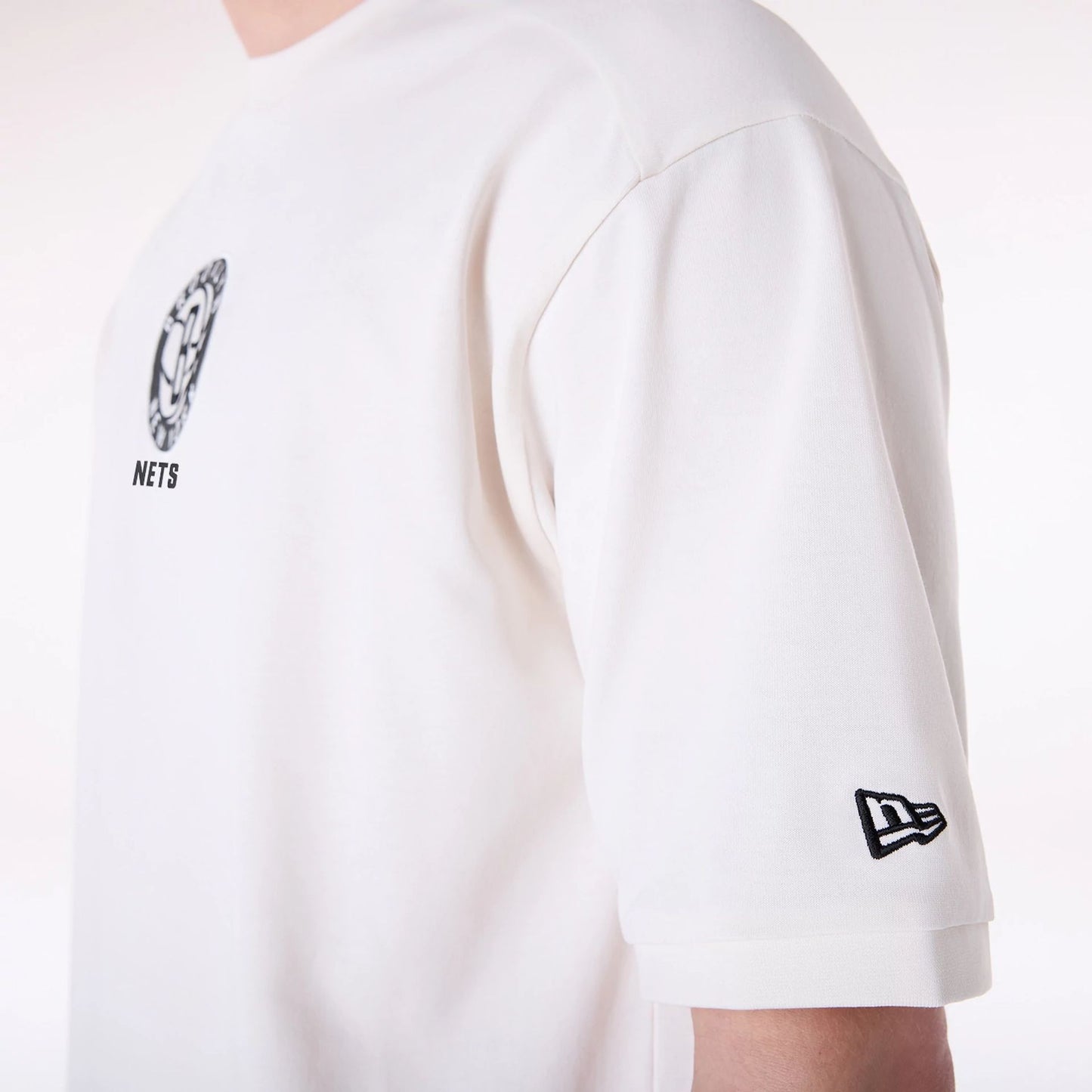 The Male model is wearing Brooklyn Nets NBA Wordmark Open White Oversized T-Shirt 5