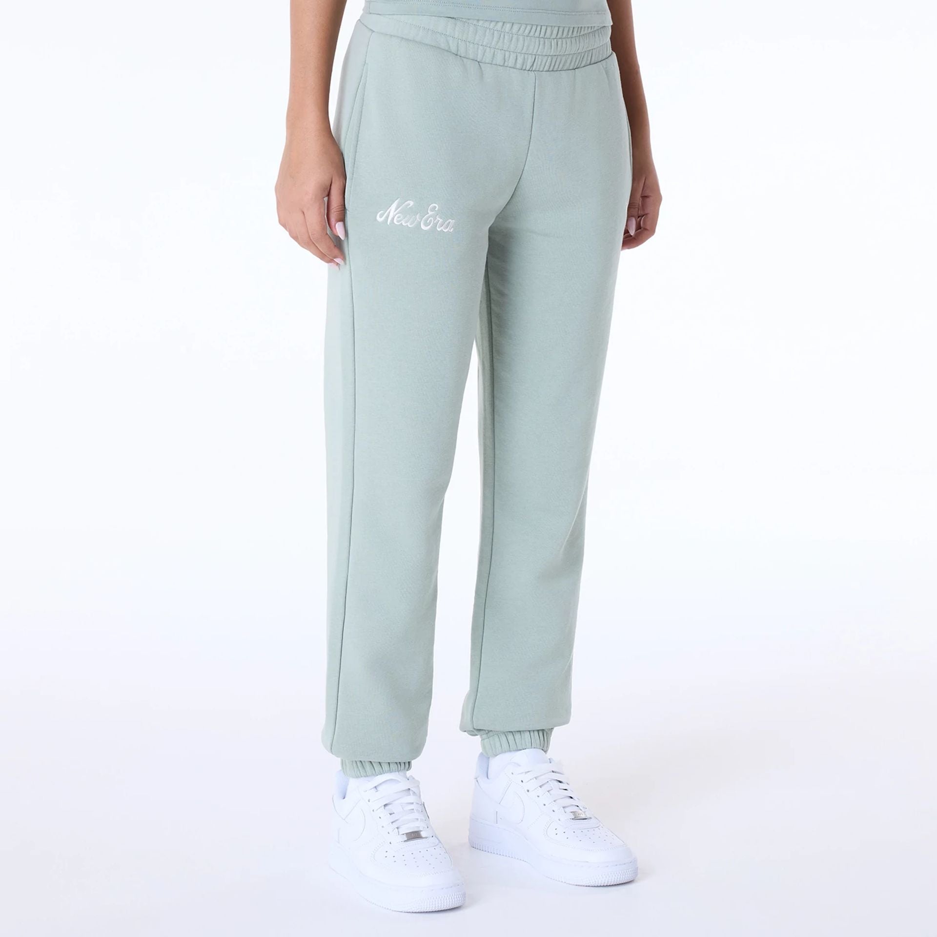 The Female model is wearing Womens New Era Script Pastel Green Joggers 1