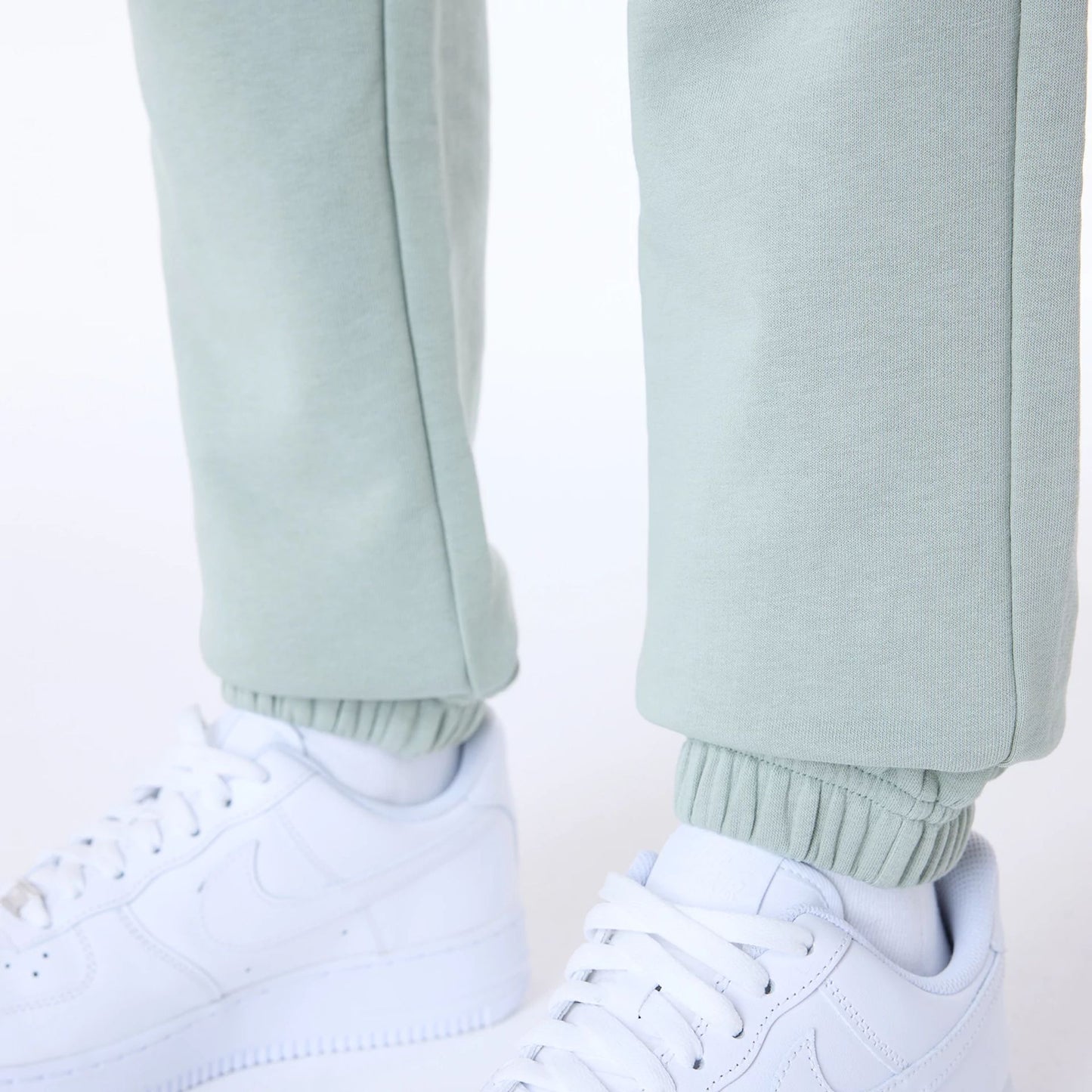 The Female model is wearing Womens New Era Script Pastel Green Joggers 6