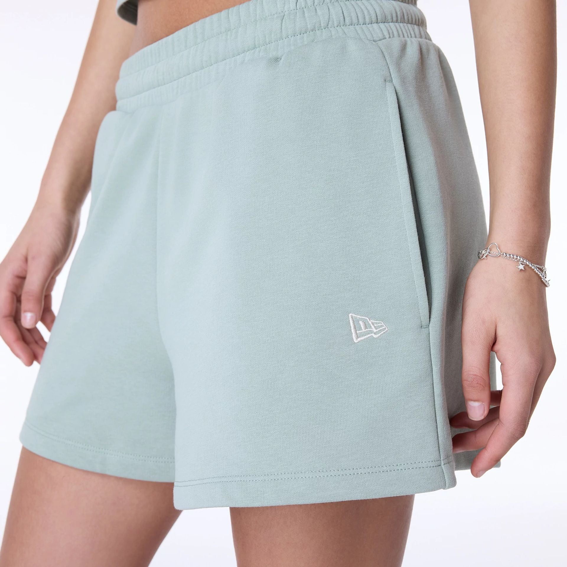 The Female model is wearing Womens New Era Script Pastel Green Shorts 4