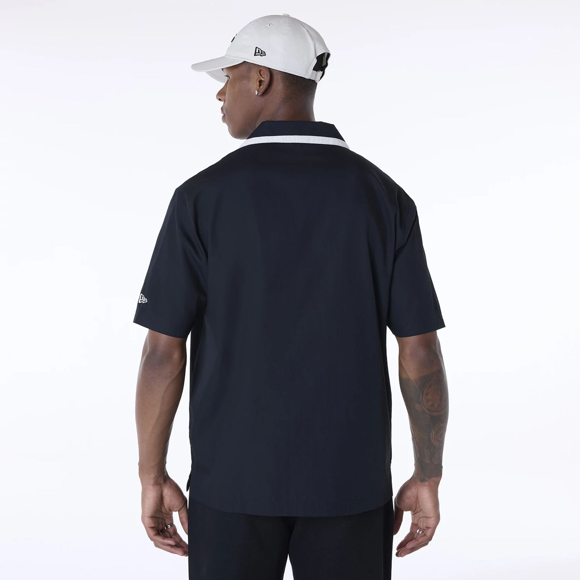 The Male model is wearing New Era Revere Black Short Sleeve Shirt 2