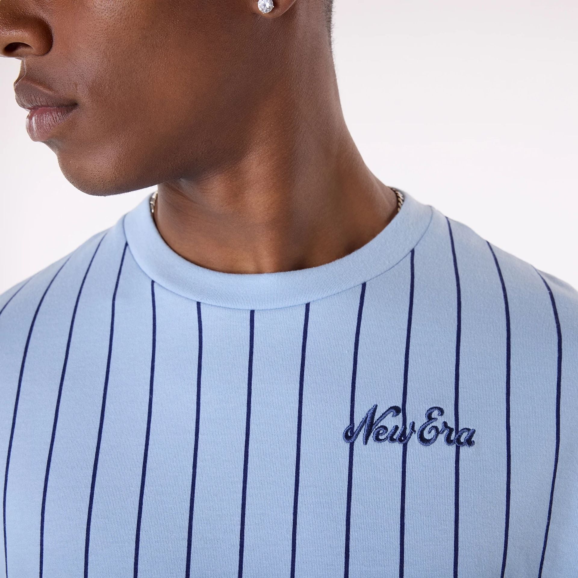 The Male model is wearing New Era Pinstripe Pastel Blue Oversized T-Shirt 3