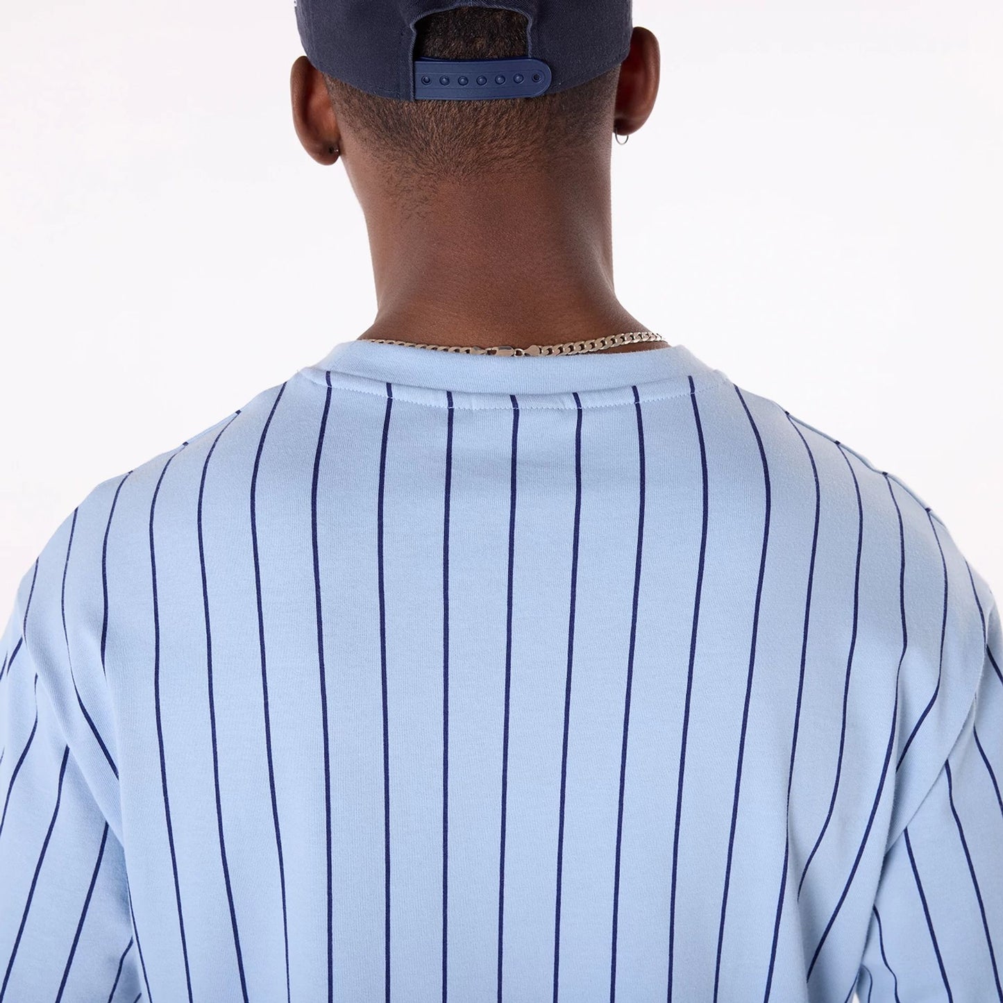 The Male model is wearing New Era Pinstripe Pastel Blue Oversized T-Shirt 4