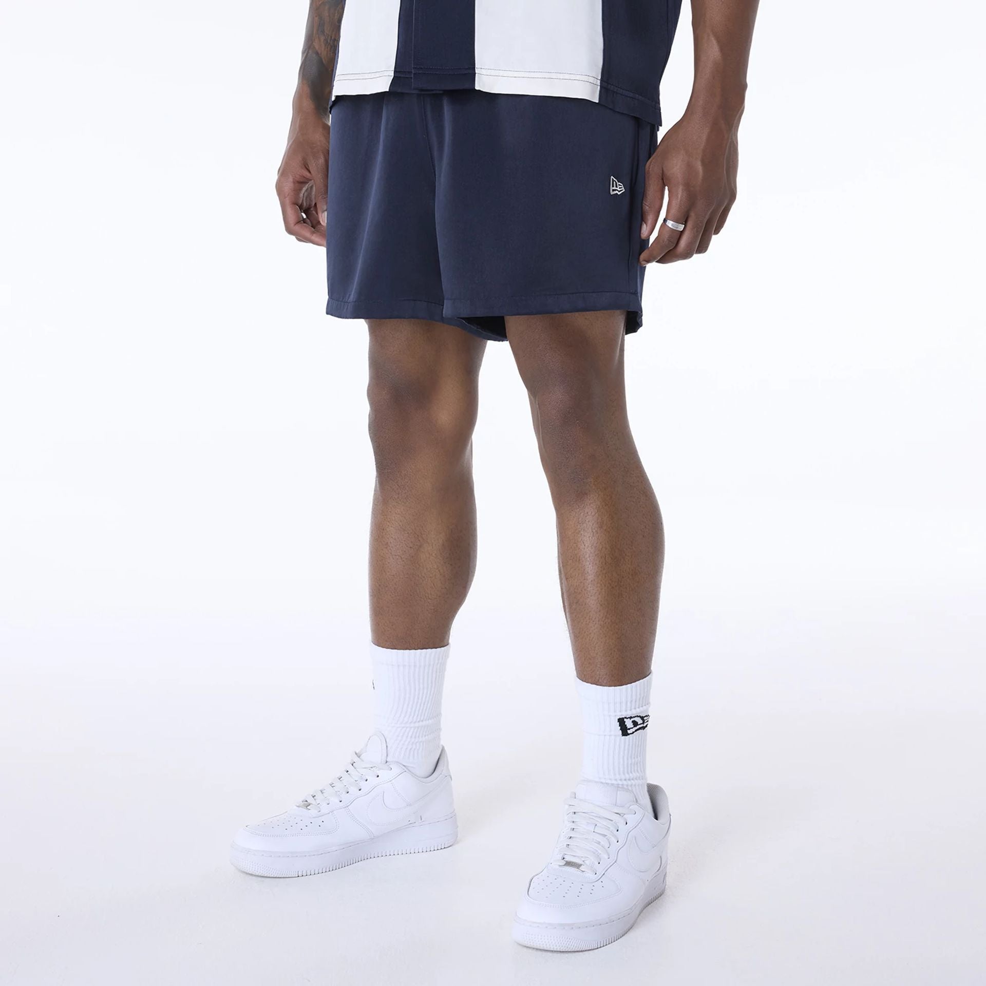 The Male model is wearing New Era Woven Navy Shorts 1