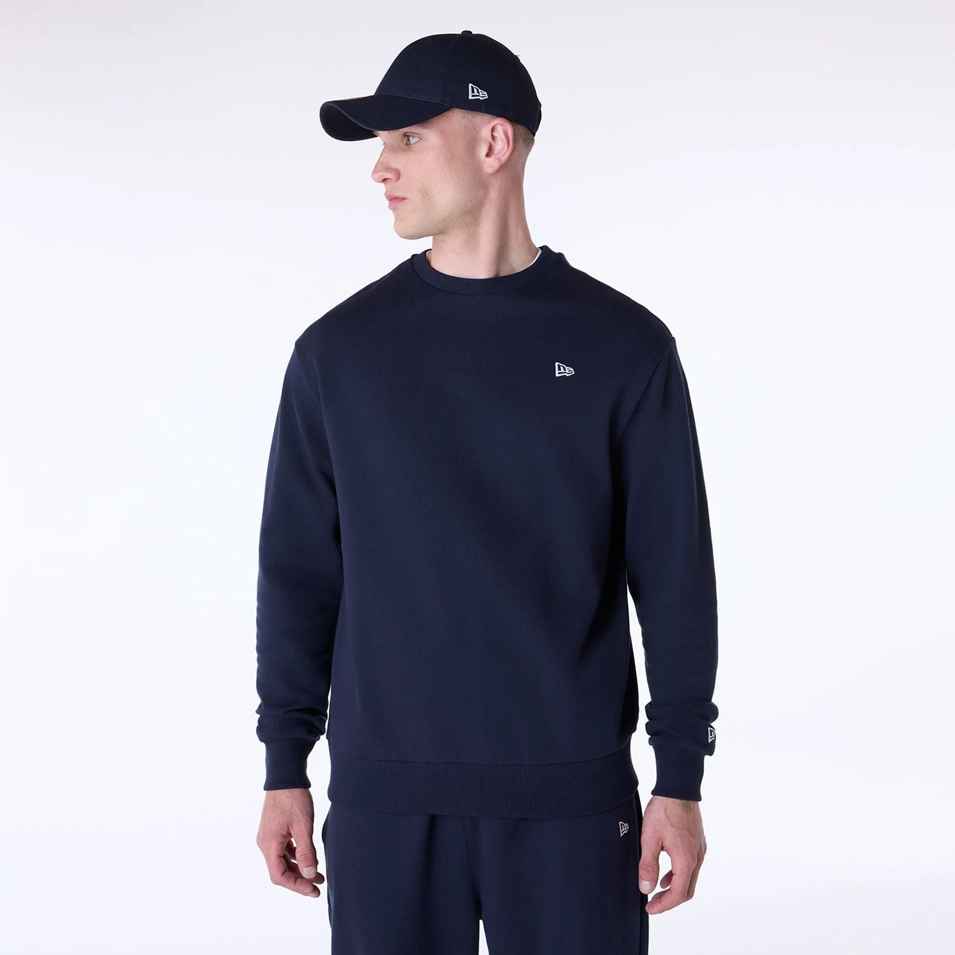 The Male model is wearing New Era Essential Navy Crew Neck Sweater 1