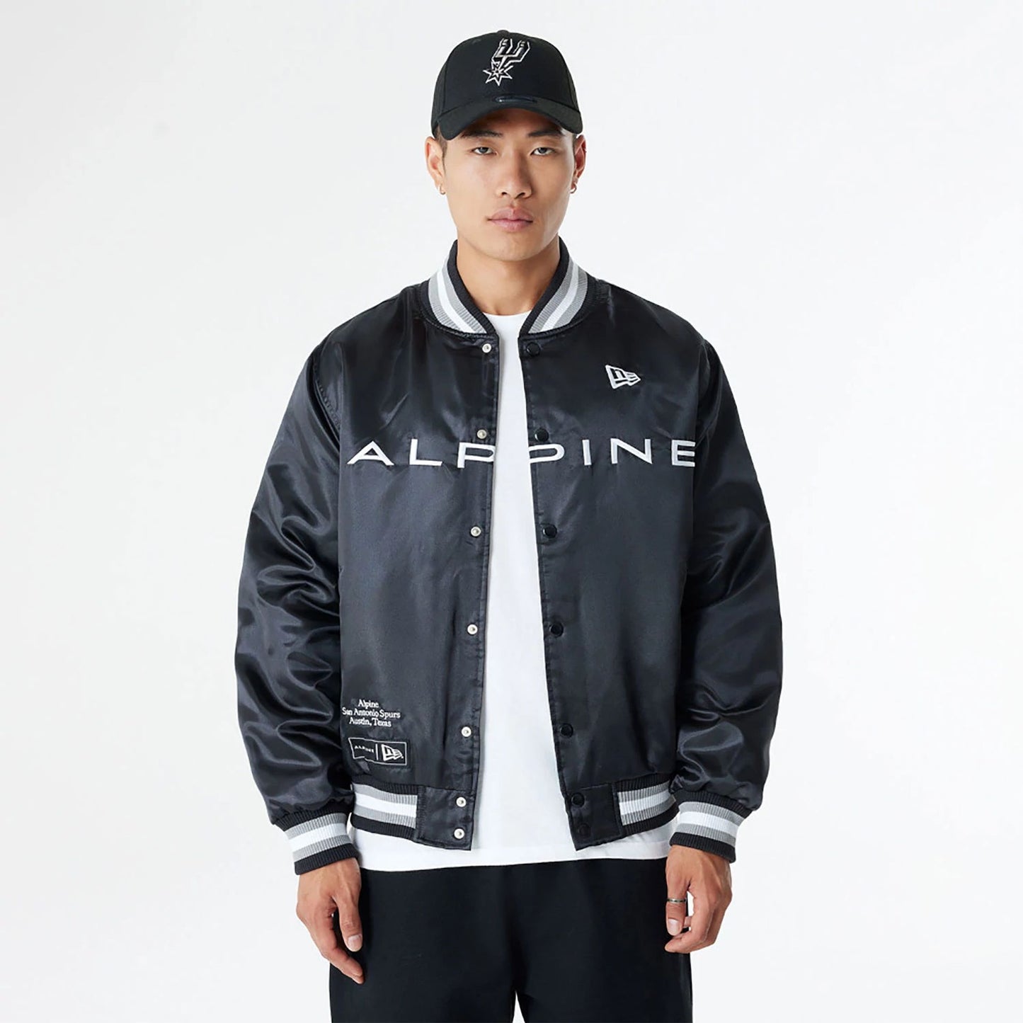 The Male model is wearing BTW Alpine F1 Racing x San Antonio Spurs Black Satin Bomber Jacket 1