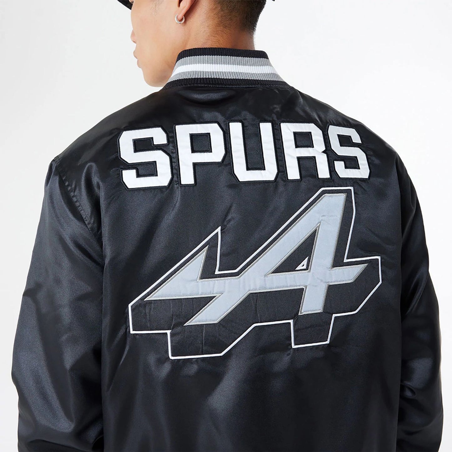 The Male model is wearing BTW Alpine F1 Racing x San Antonio Spurs Black Satin Bomber Jacket 7