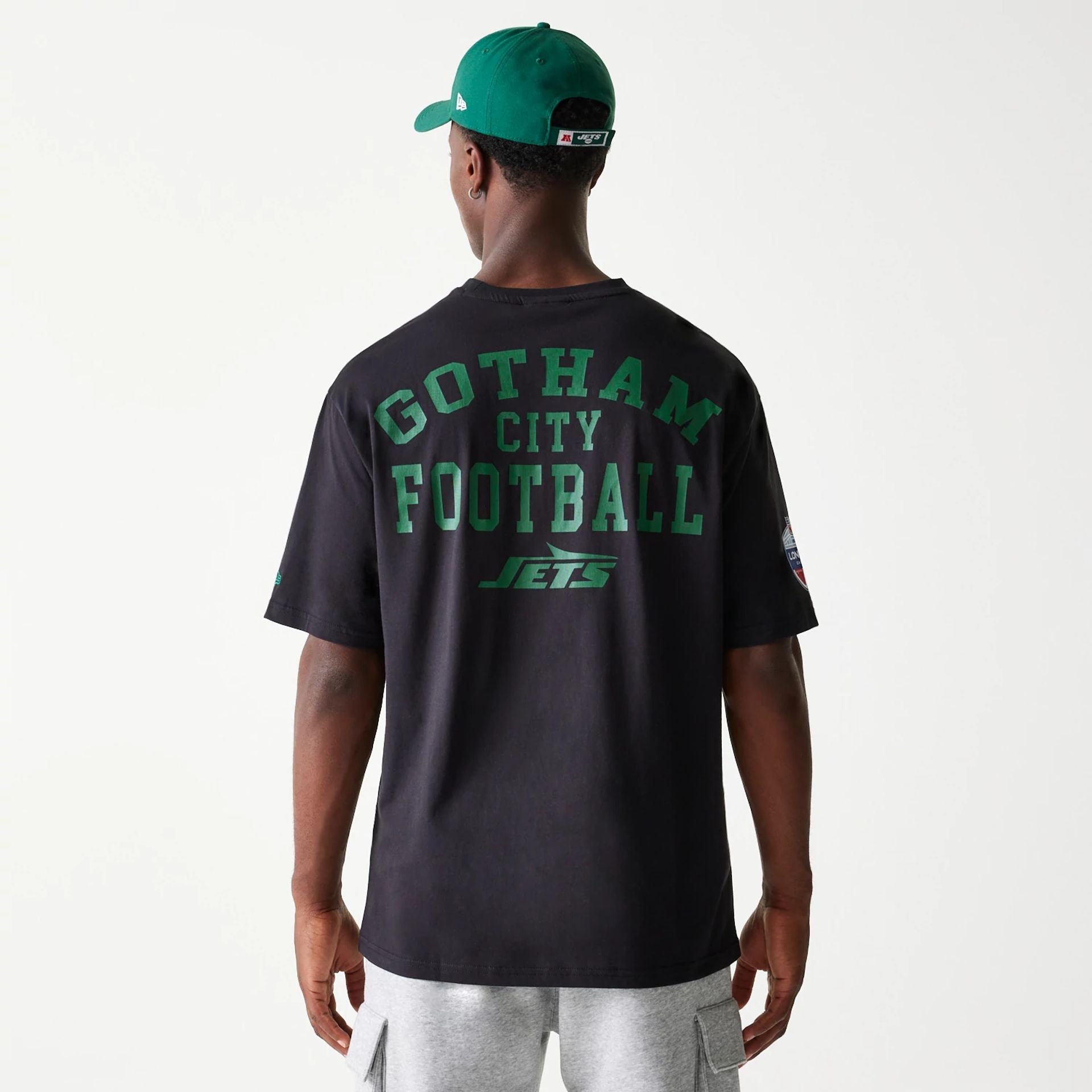 The Male model is wearing New York Jets NFL Games Square Arch Black Oversized T-Shirt 7