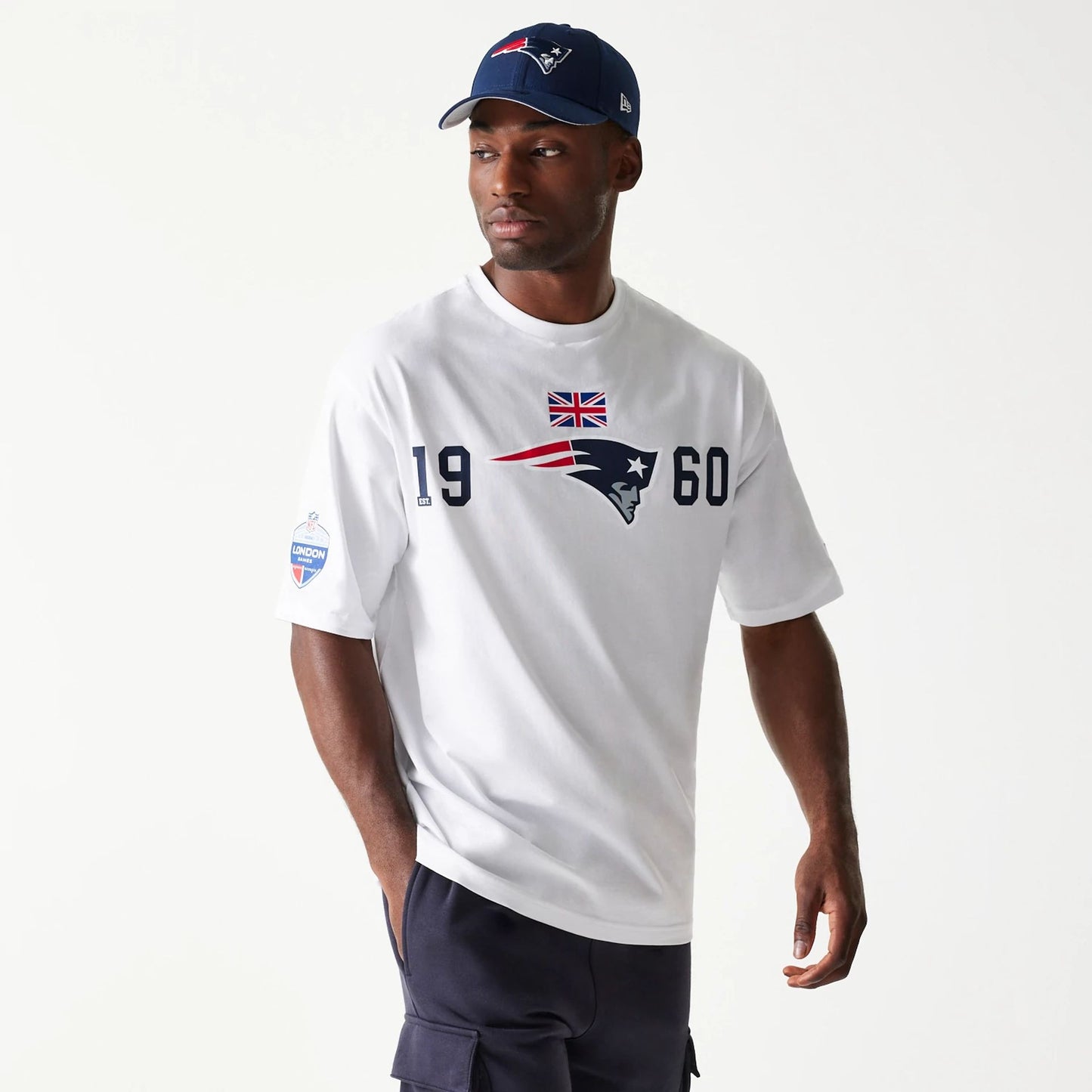 The Male model is wearing New England Patriots NFL Games Square Arch White Oversized T-Shirt 1