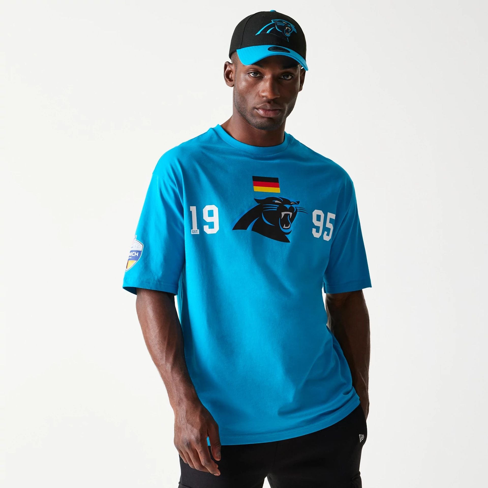 The Male model is wearing Carolina Panthers NFL Games Square Arch Bright Blue Oversized T-Shirt 1