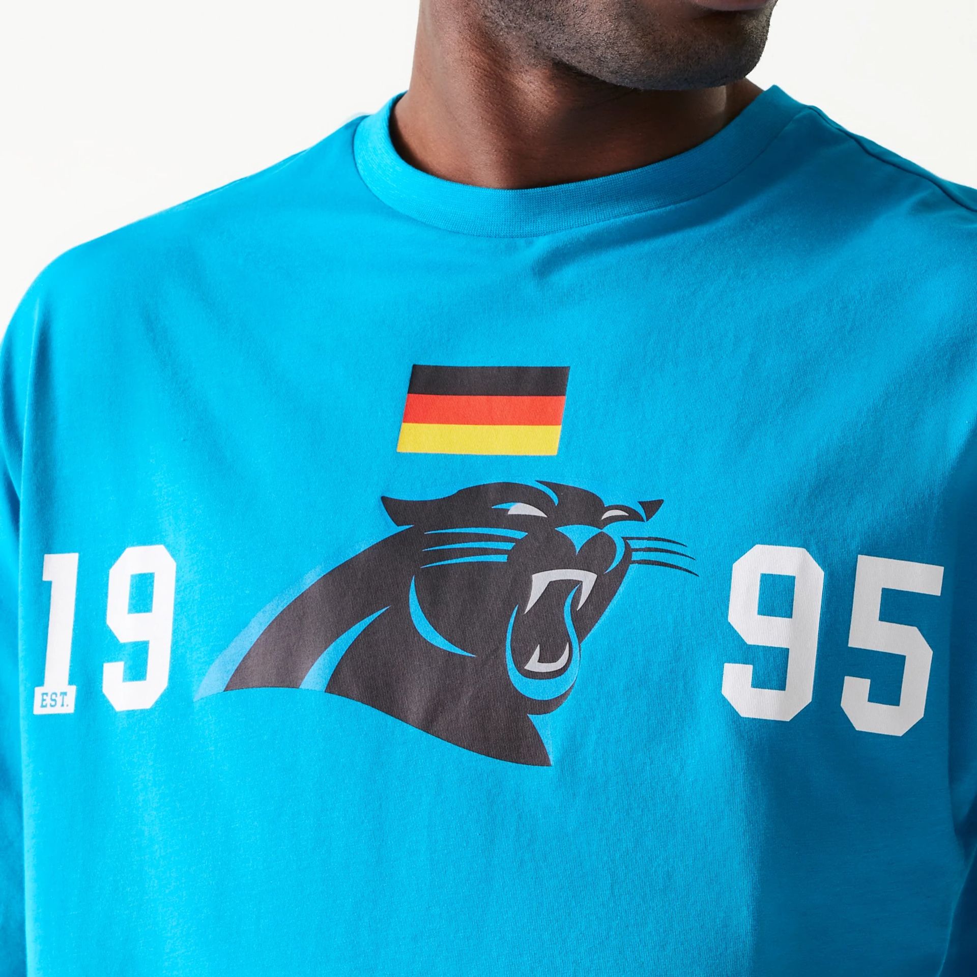 The Male model is wearing Carolina Panthers NFL Games Square Arch Bright Blue Oversized T-Shirt 5