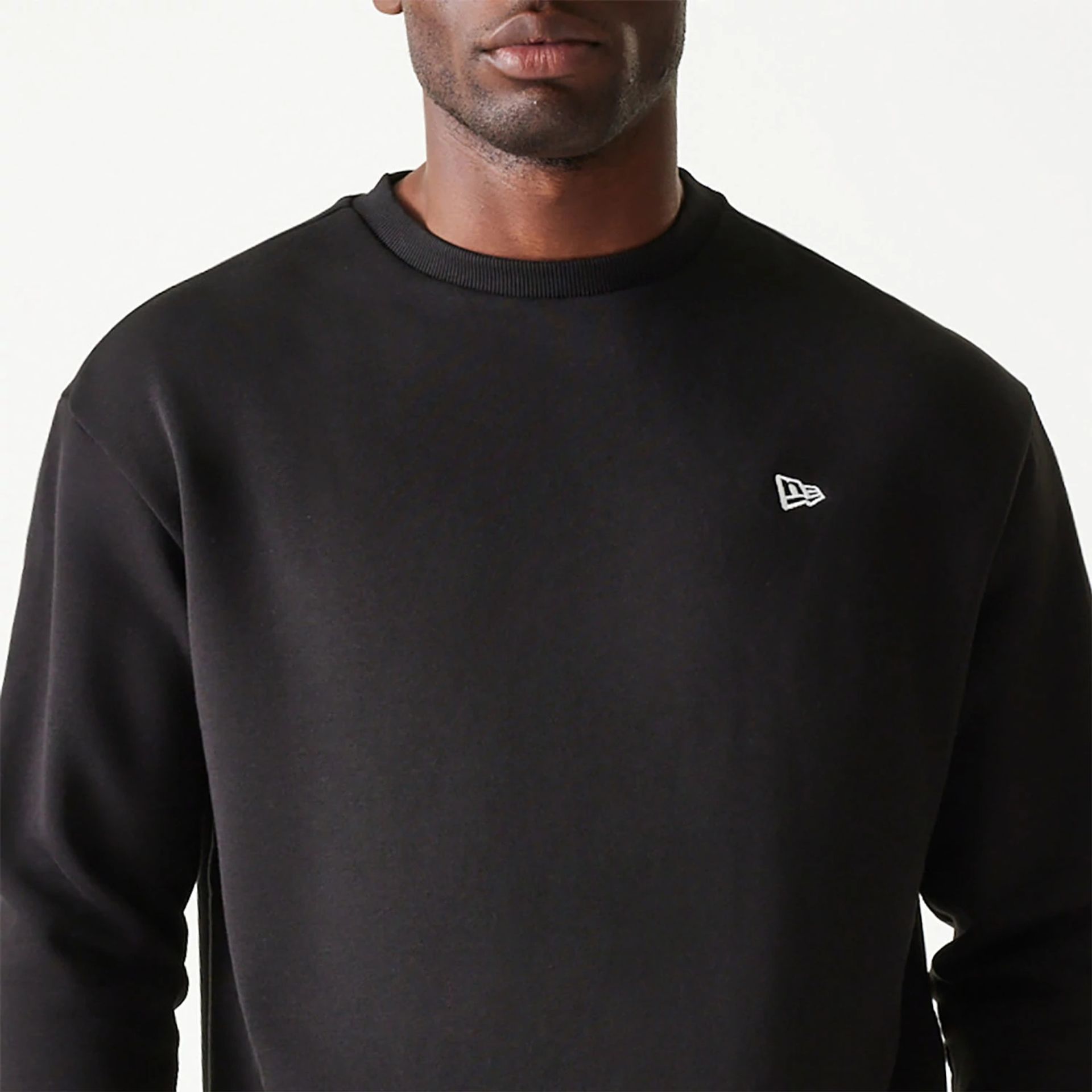 The Male model is wearing New Era Essential Brushed Fleece Black Crewneck Sweater 3