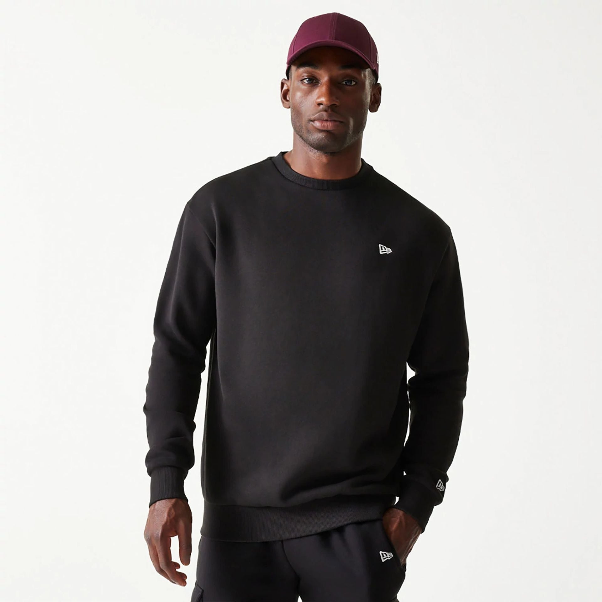 The Male model is wearing New Era Essential Brushed Fleece Black Crewneck Sweater 1