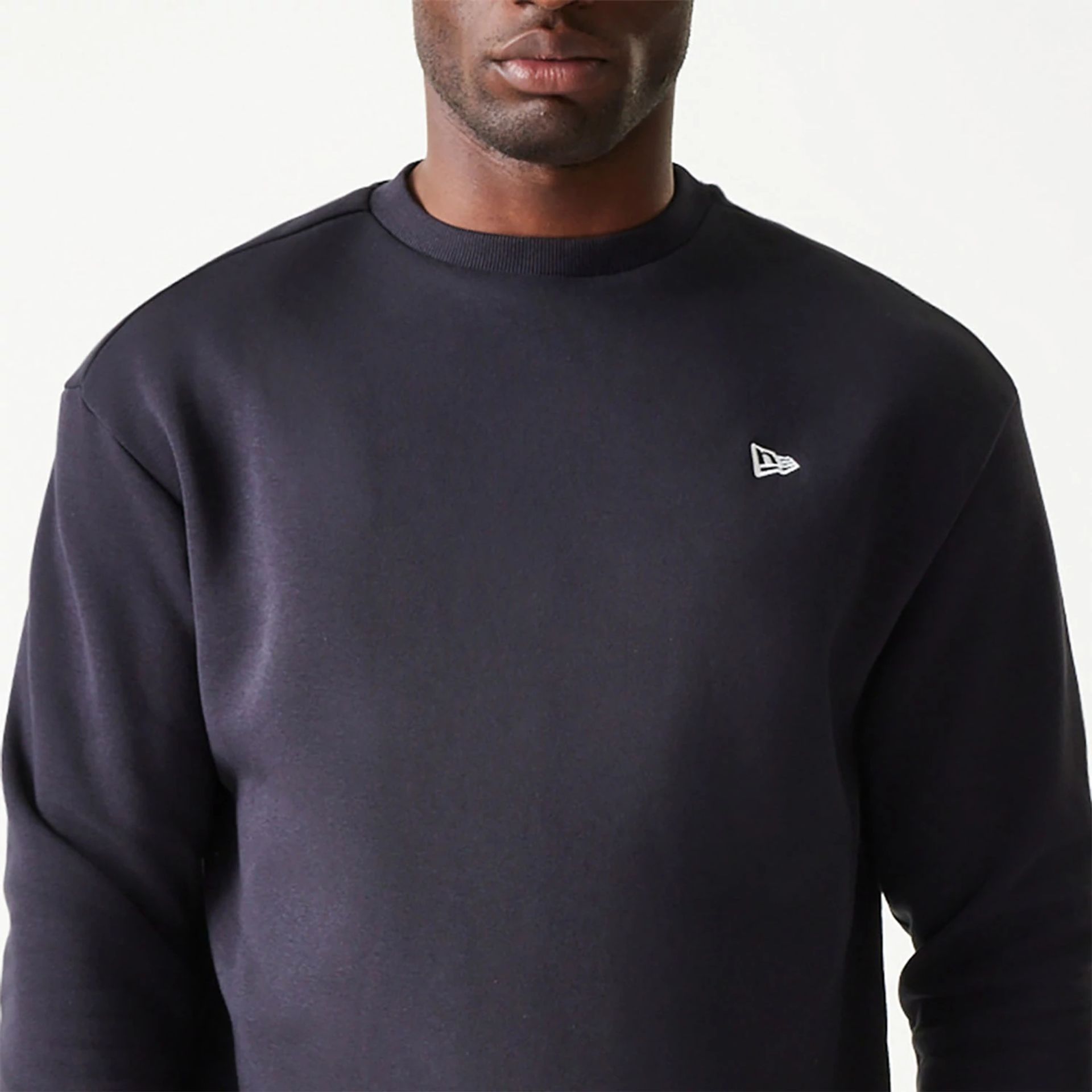 The Male model is wearing New Era Essential Brushed Fleece Navy Crewneck Sweater 3