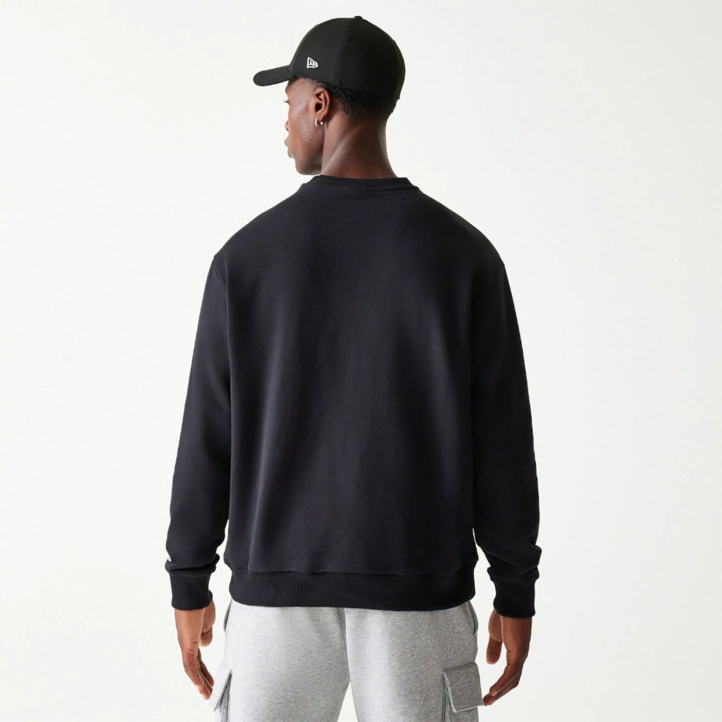 The Male model is wearing New Era Essential Black Crewneck Sweater 2