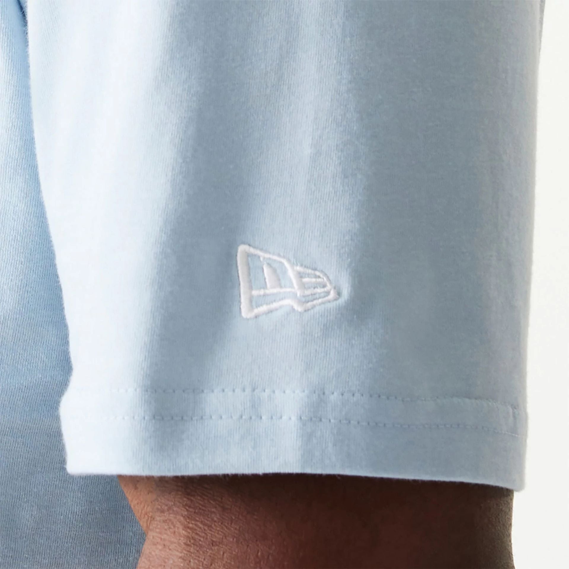 The Male model is wearing New Era Essential Pastel Blue Oversized T-Shirt 5