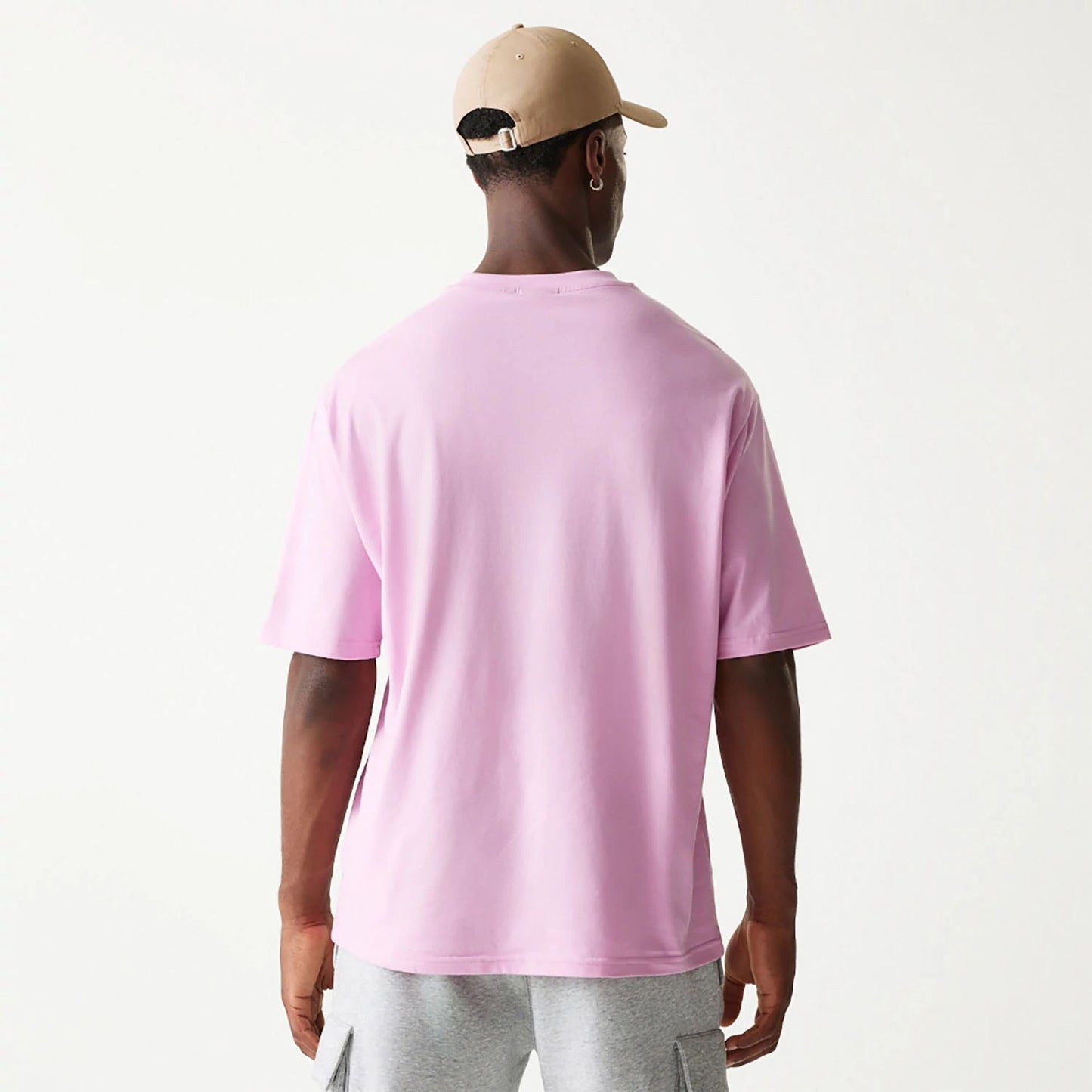 The Male model is wearing New Era Essential Pastel Pink Oversized T-Shirt 2