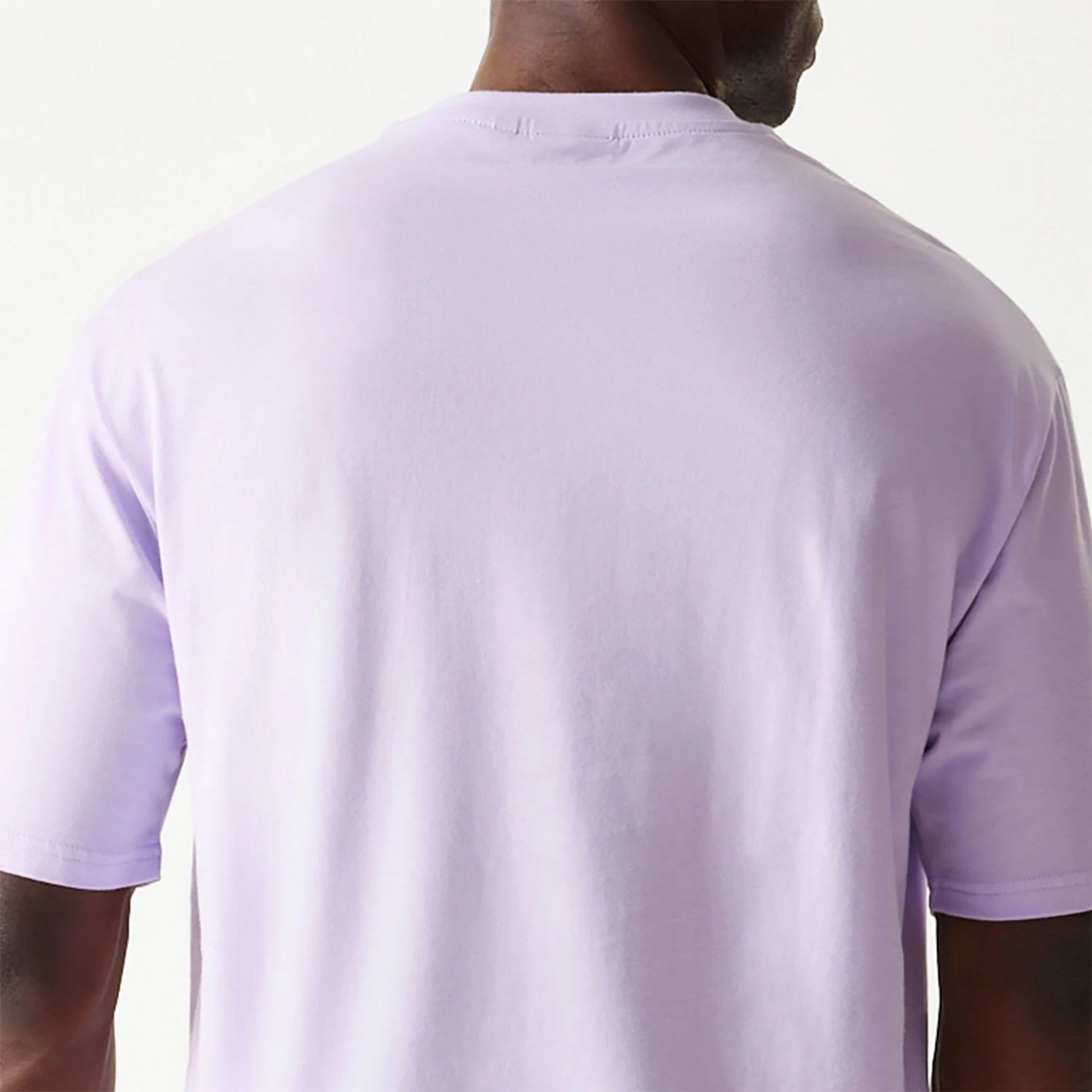 The Male model is wearing New Era Essential Pastel Purple Oversized T-Shirt 5