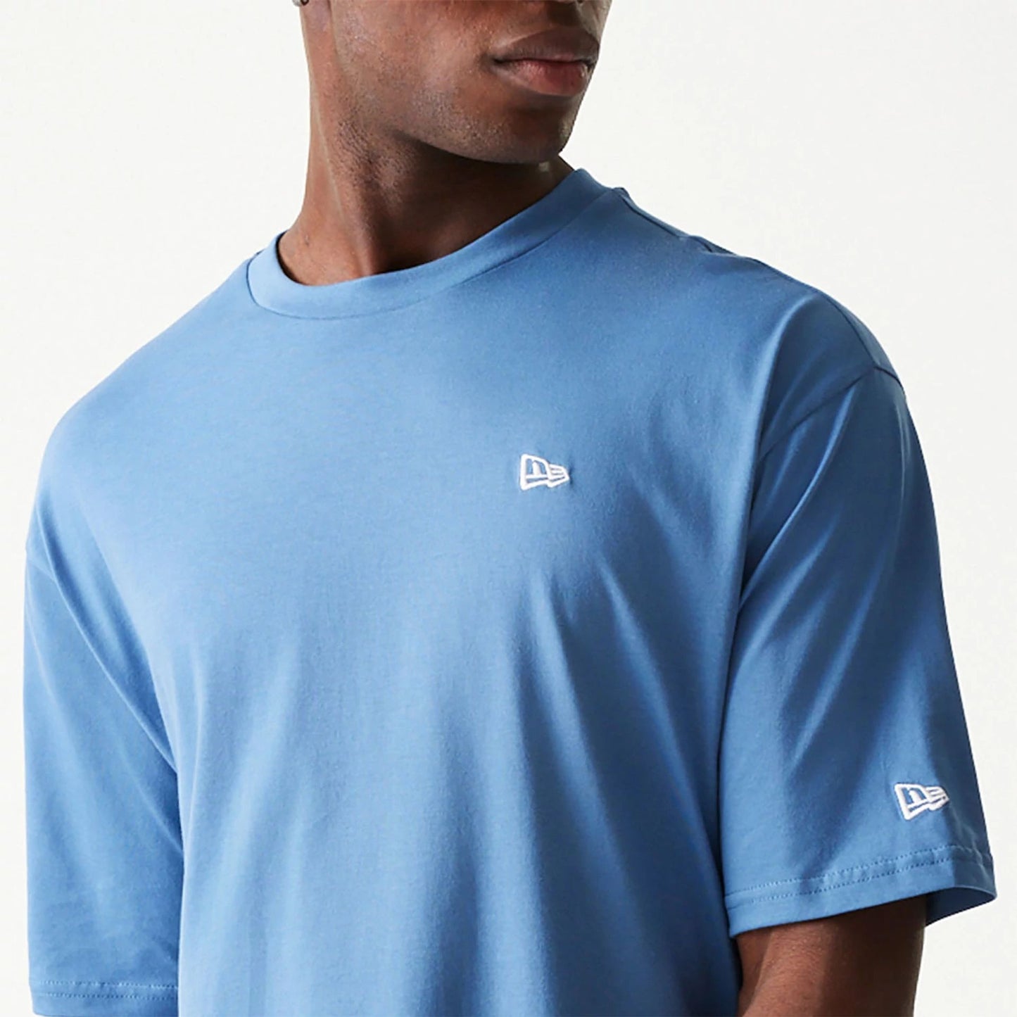 The Male model is wearing New Era Essential Blue Oversized T-Shirt 3