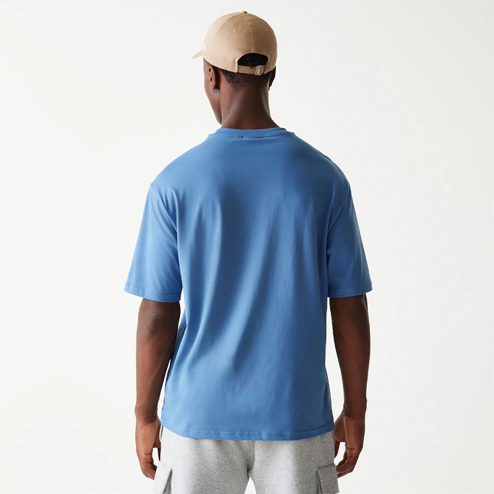 The Male model is wearing New Era Essential Blue Oversized T-Shirt 2