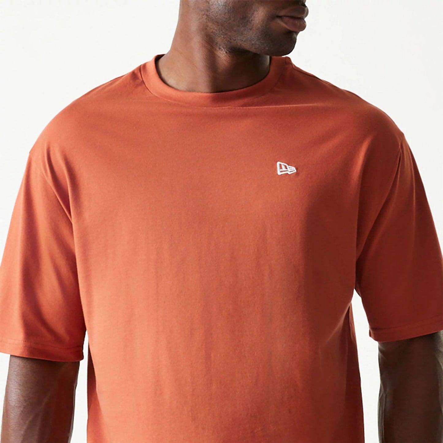 The Male model is wearing New Era Essential Brown Oversized T-Shirt 3