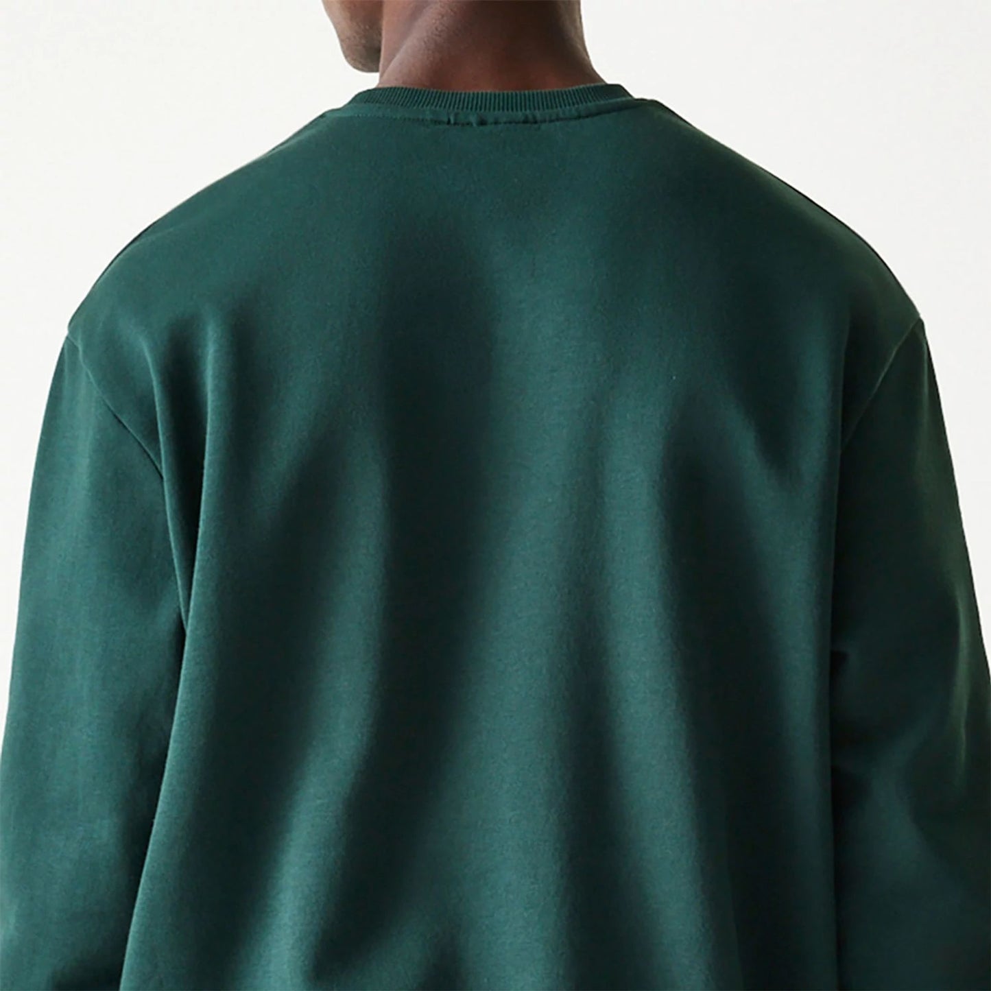 The Male model is wearing New Era Essential Brushed Fleece Dark Green Crewneck Sweater 7