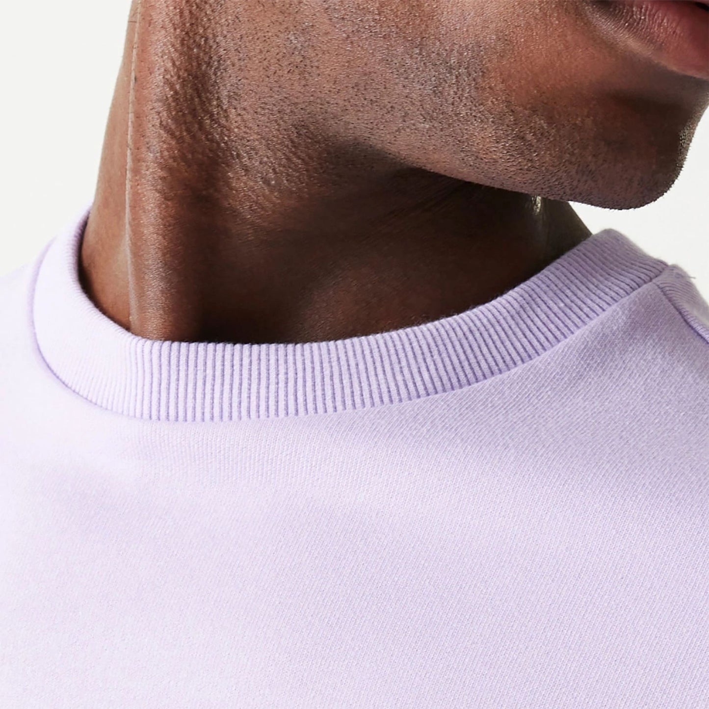 The Male model is wearing New Era Essential Pastel Purple Crewneck Sweater 6