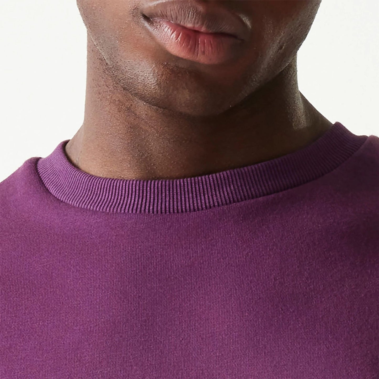 The Male model is wearing New Era Essential Brushed Fleece Dark Purple Crewneck Sweater 6