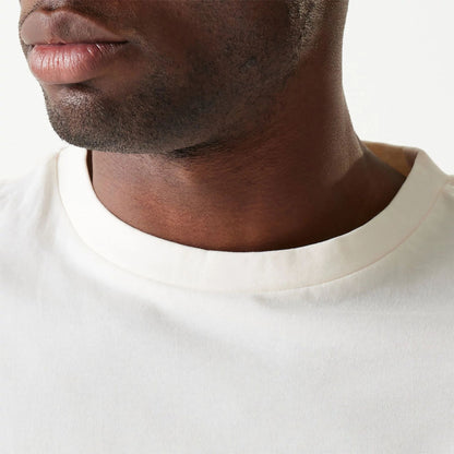 The Male model is wearing New Era Essential Cream Oversized T-Shirt 6