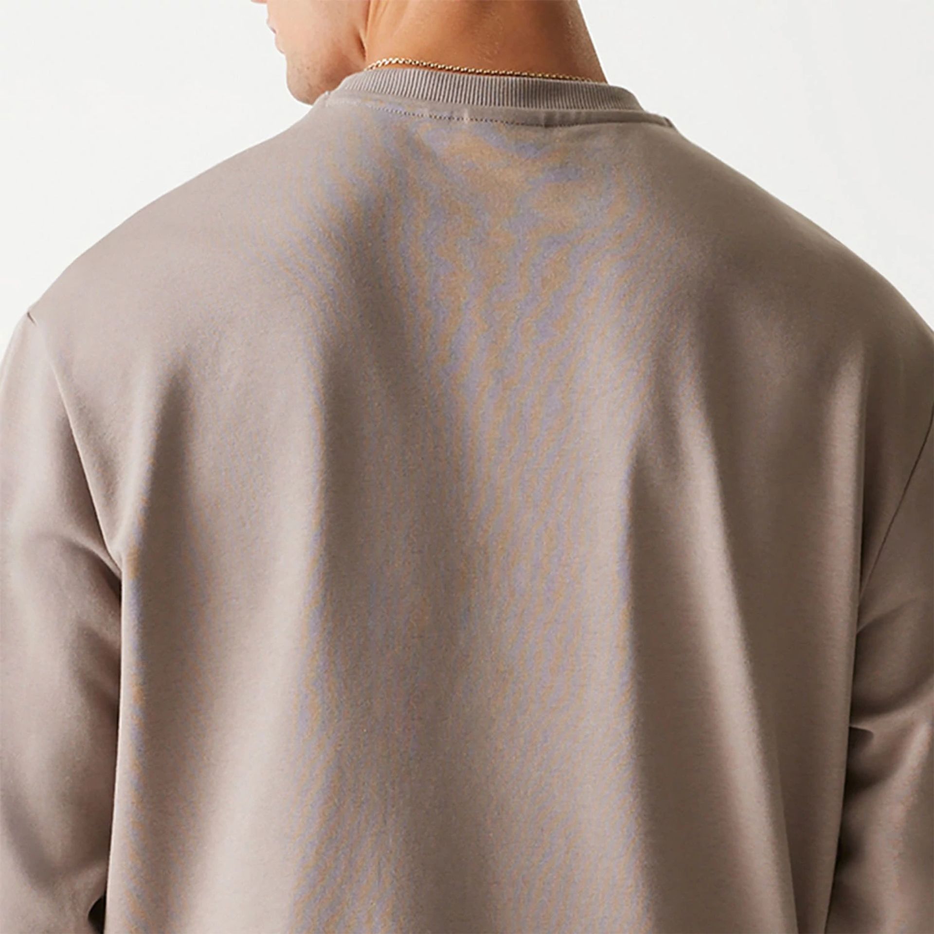 The Male model is wearing New Era Essential Brushed Fleece Pastel Brown Crewneck Sweater 7