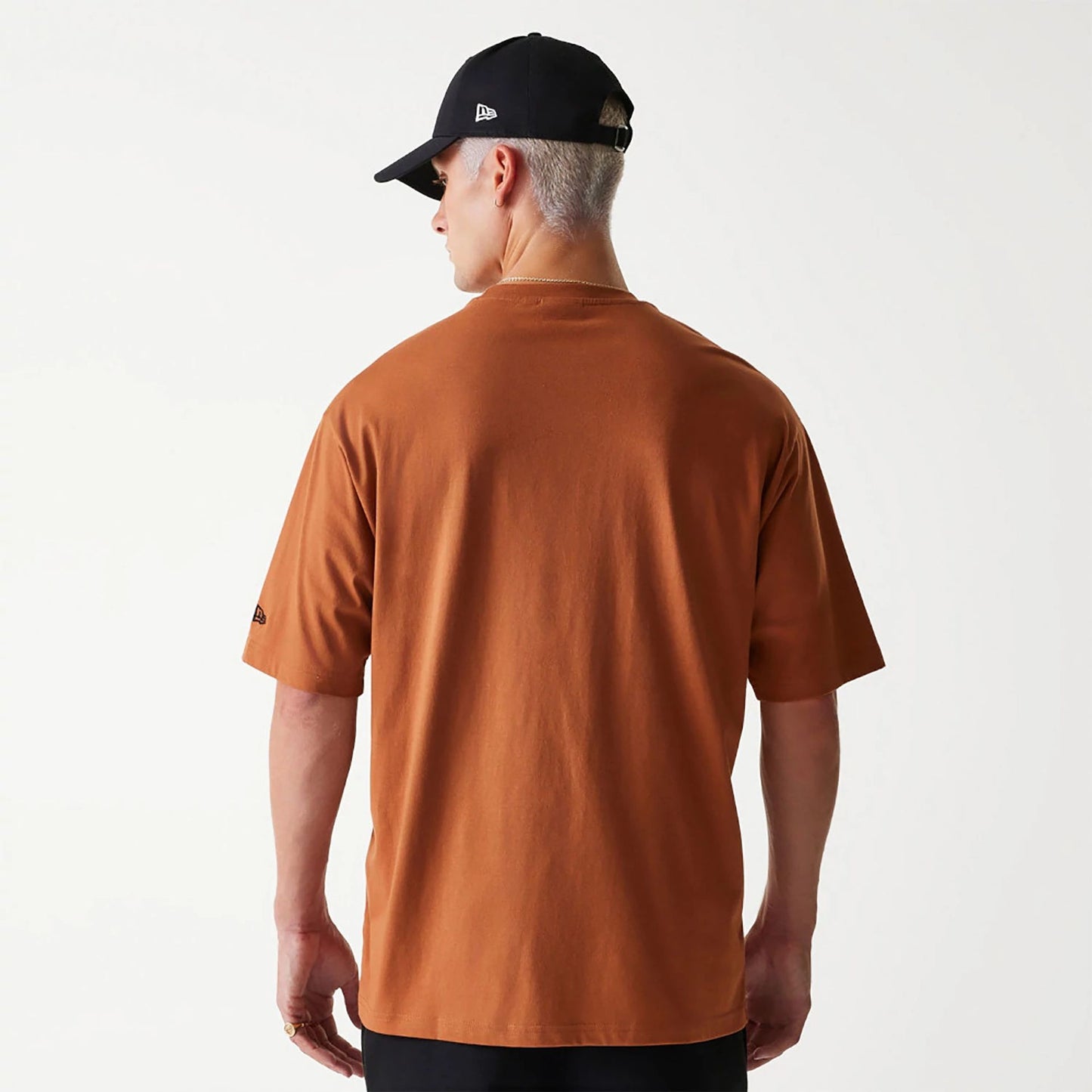 The Male model is wearing New Era Essential Brown Oversized T-Shirt 2