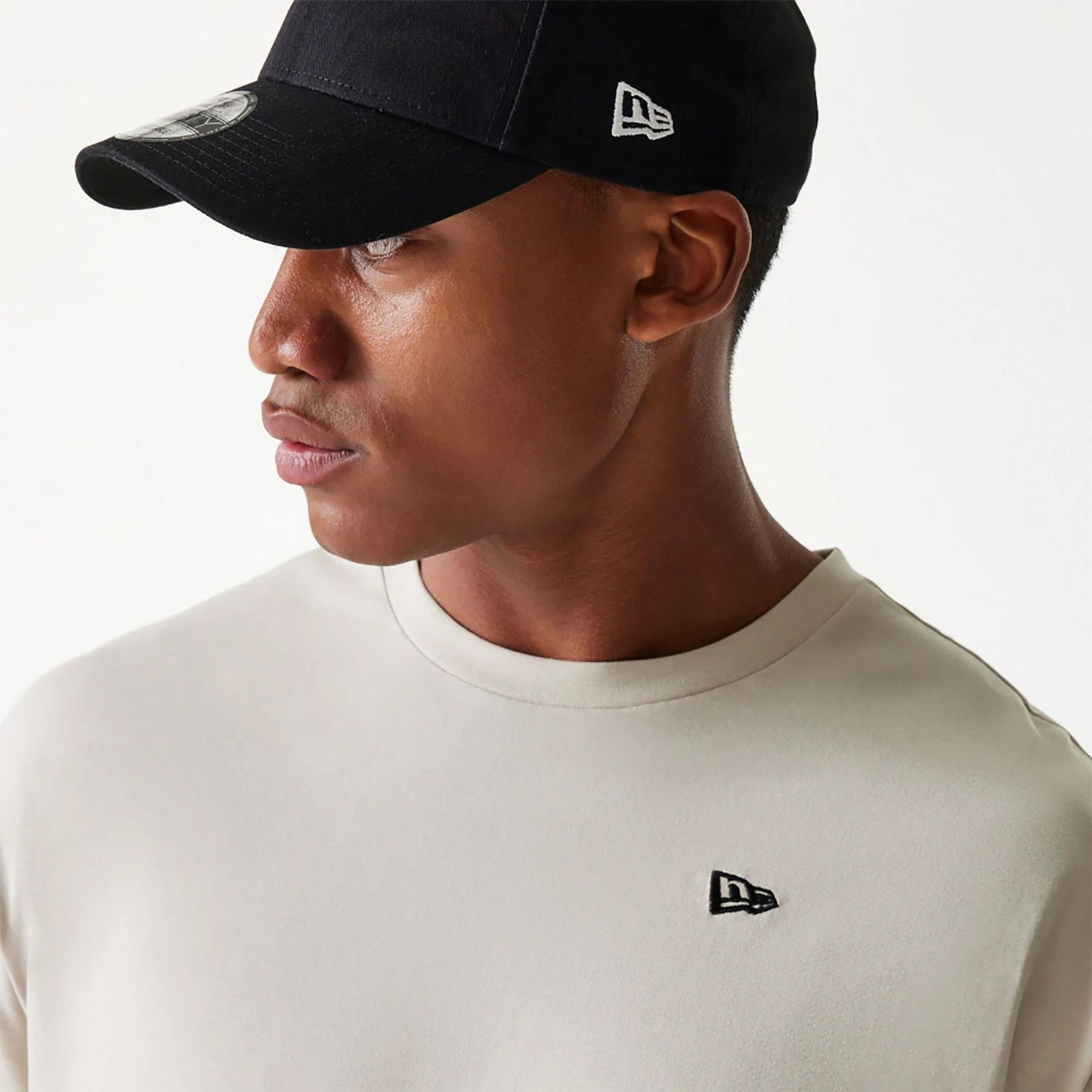 The Male model is wearing New Era Essential Light Beige Oversized T-Shirt 4