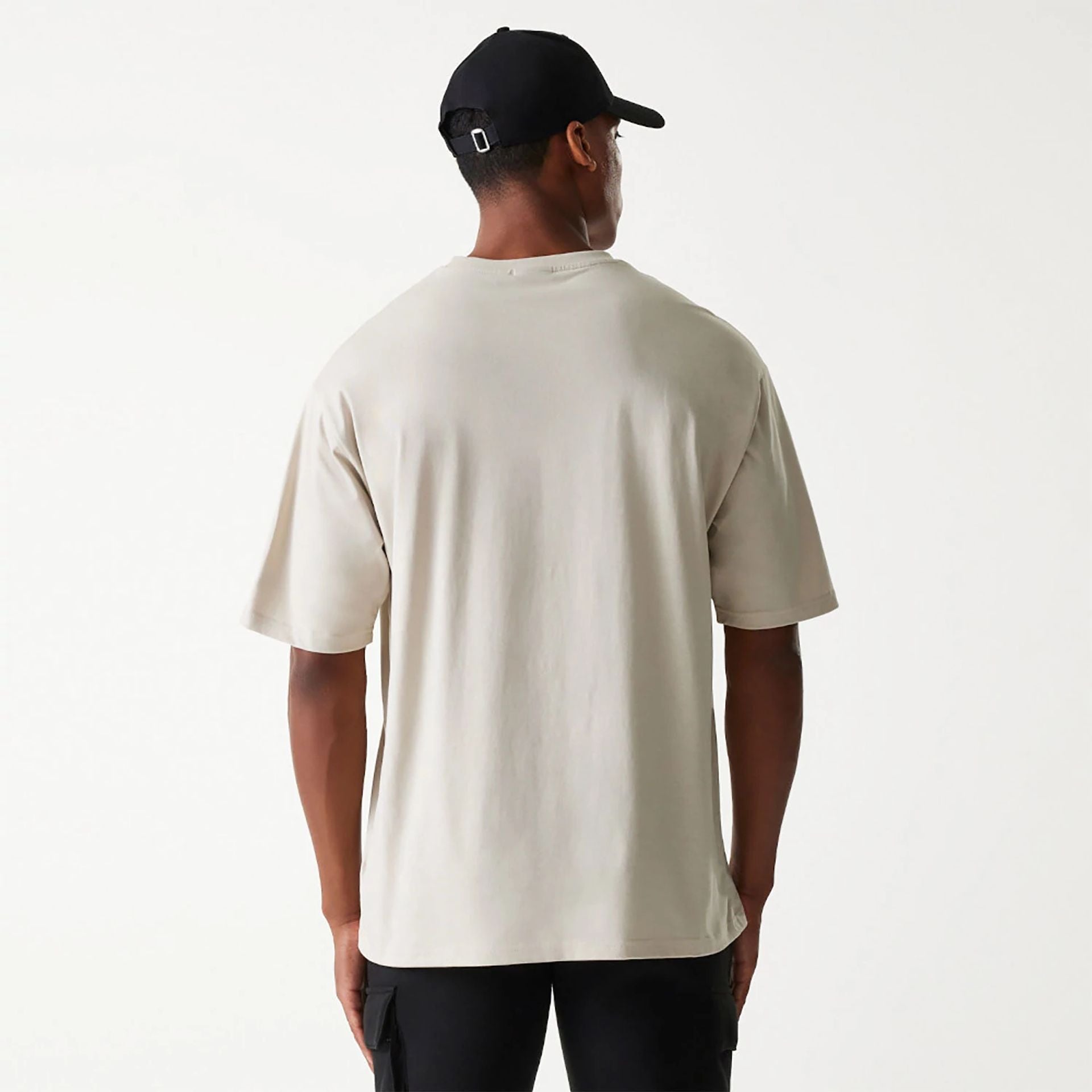 The Male model is wearing New Era Essential Light Beige Oversized T-Shirt 2