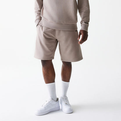 The Male model is wearing New Era Pastel Brown Oversized One Panel Shorts 1