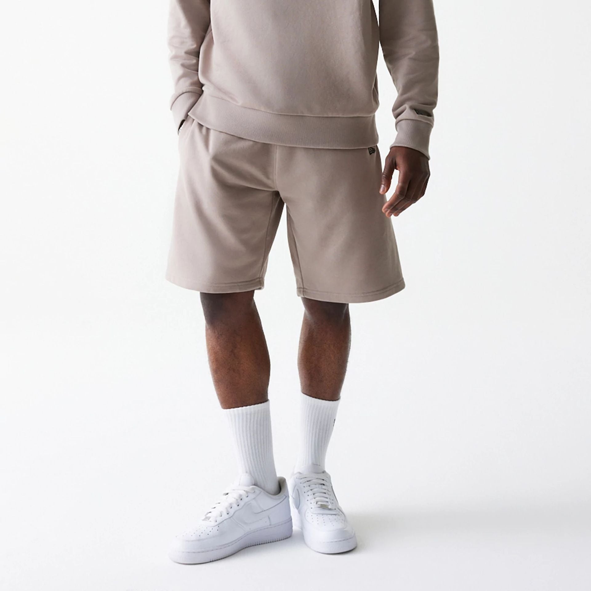 The Male model is wearing New Era Pastel Brown Oversized One Panel Shorts 1