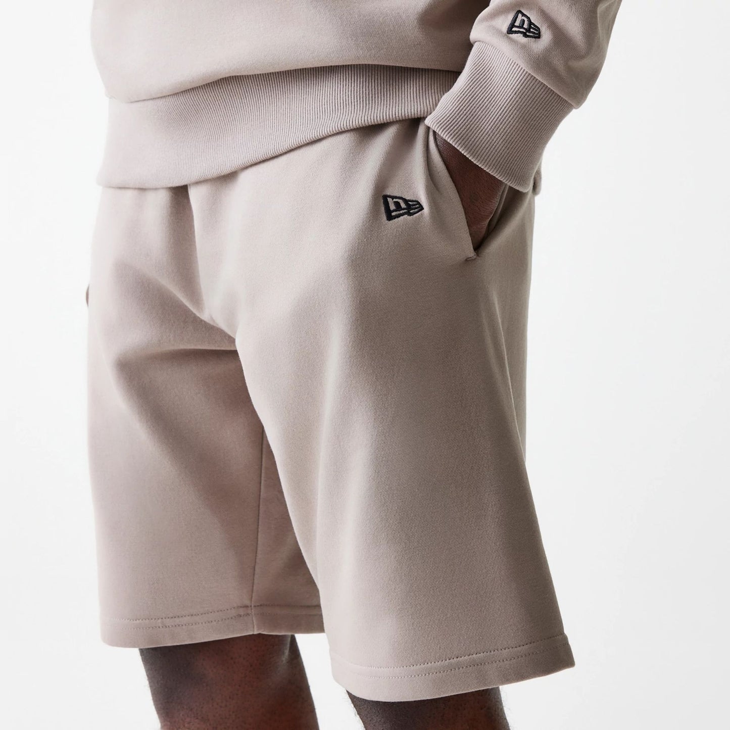 The Male model is wearing New Era Pastel Brown Oversized One Panel Shorts 3