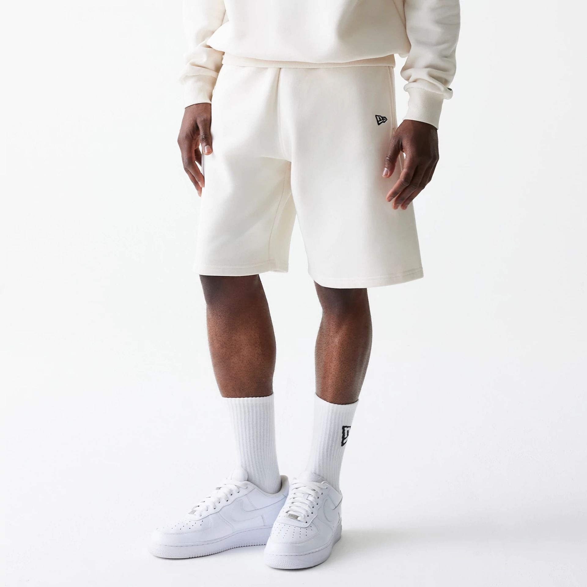 The Male model is wearing New Era Open White Oversized One Panel Shorts 1