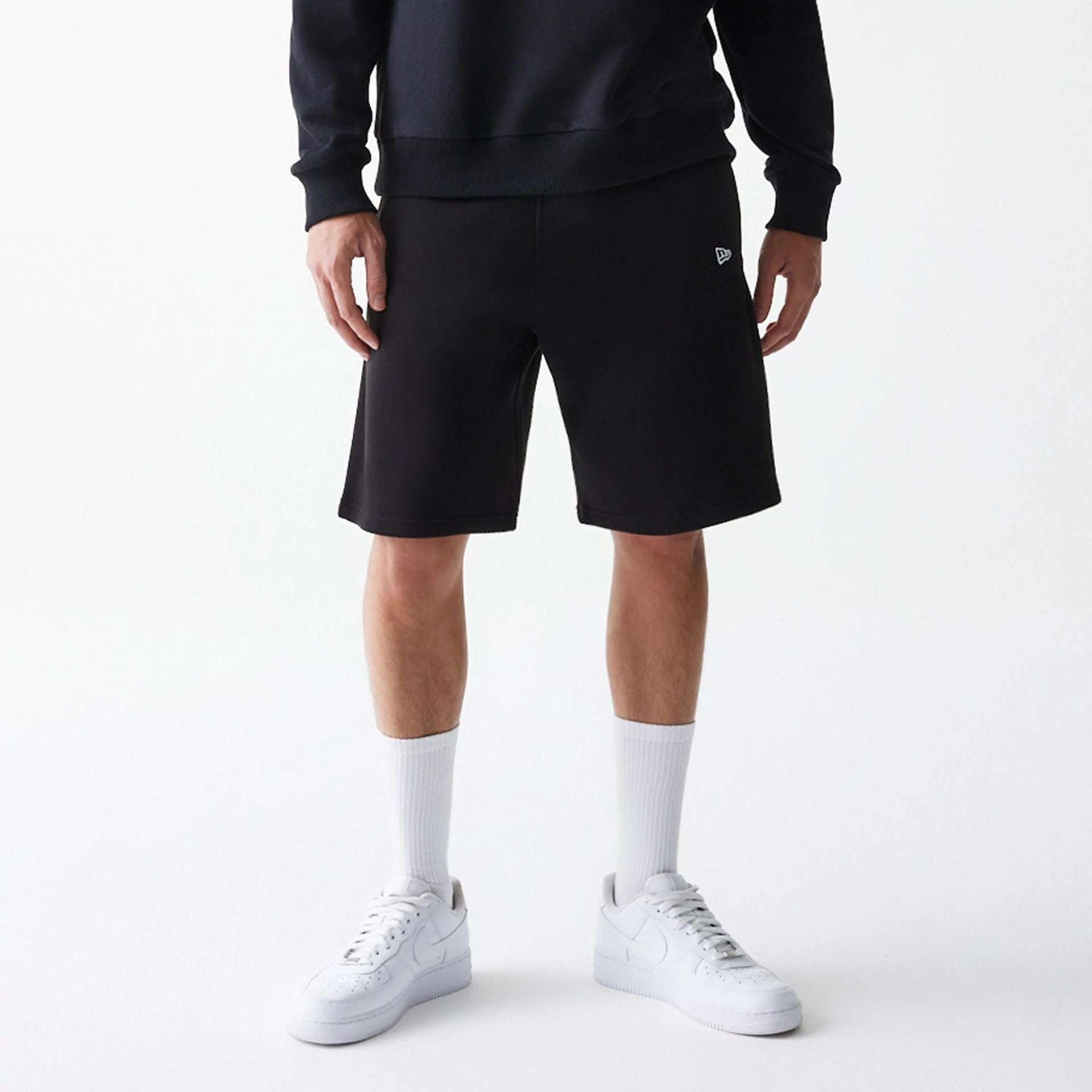 The Male model is wearing New Era Black Oversized One Panel Shorts 1