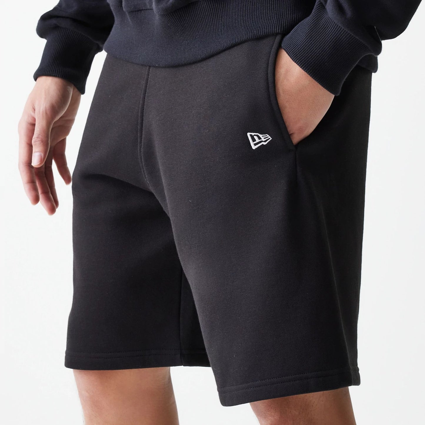 The Male model is wearing New Era Black Oversized One Panel Shorts 3