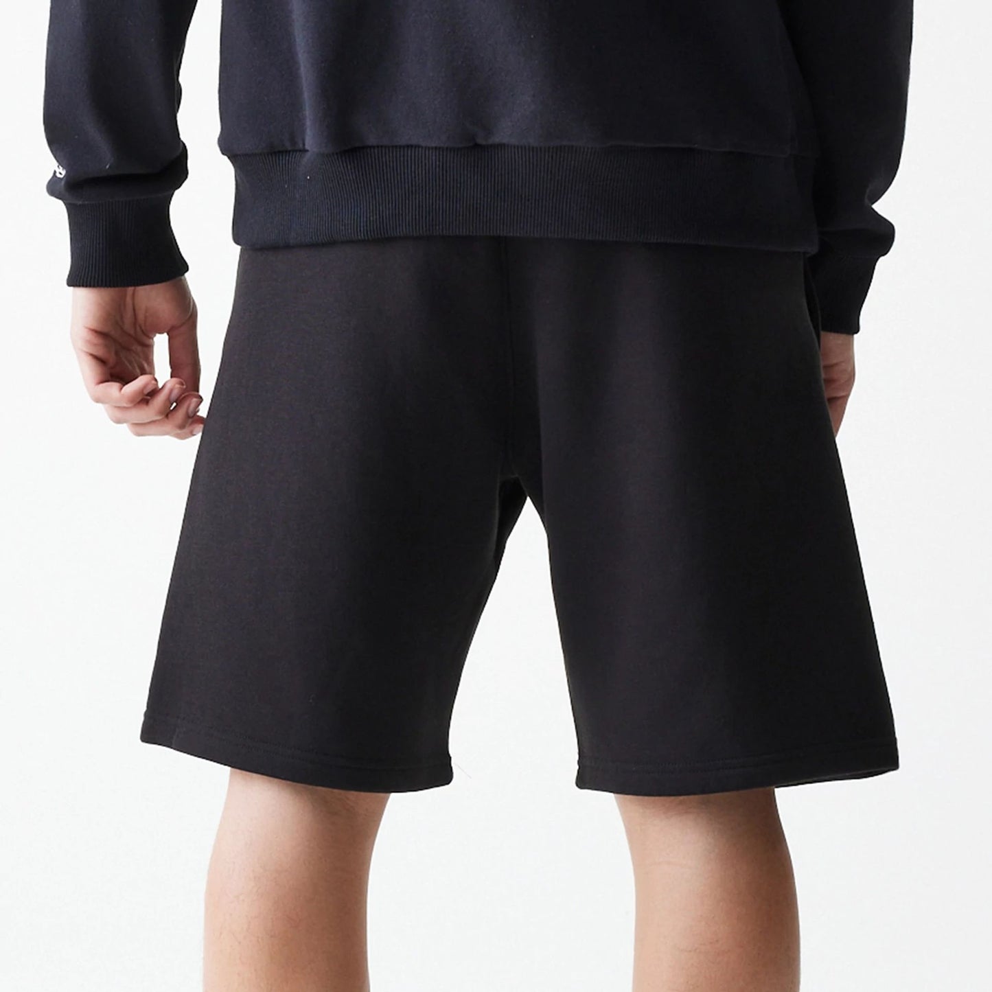 The Male model is wearing New Era Black Oversized One Panel Shorts 7