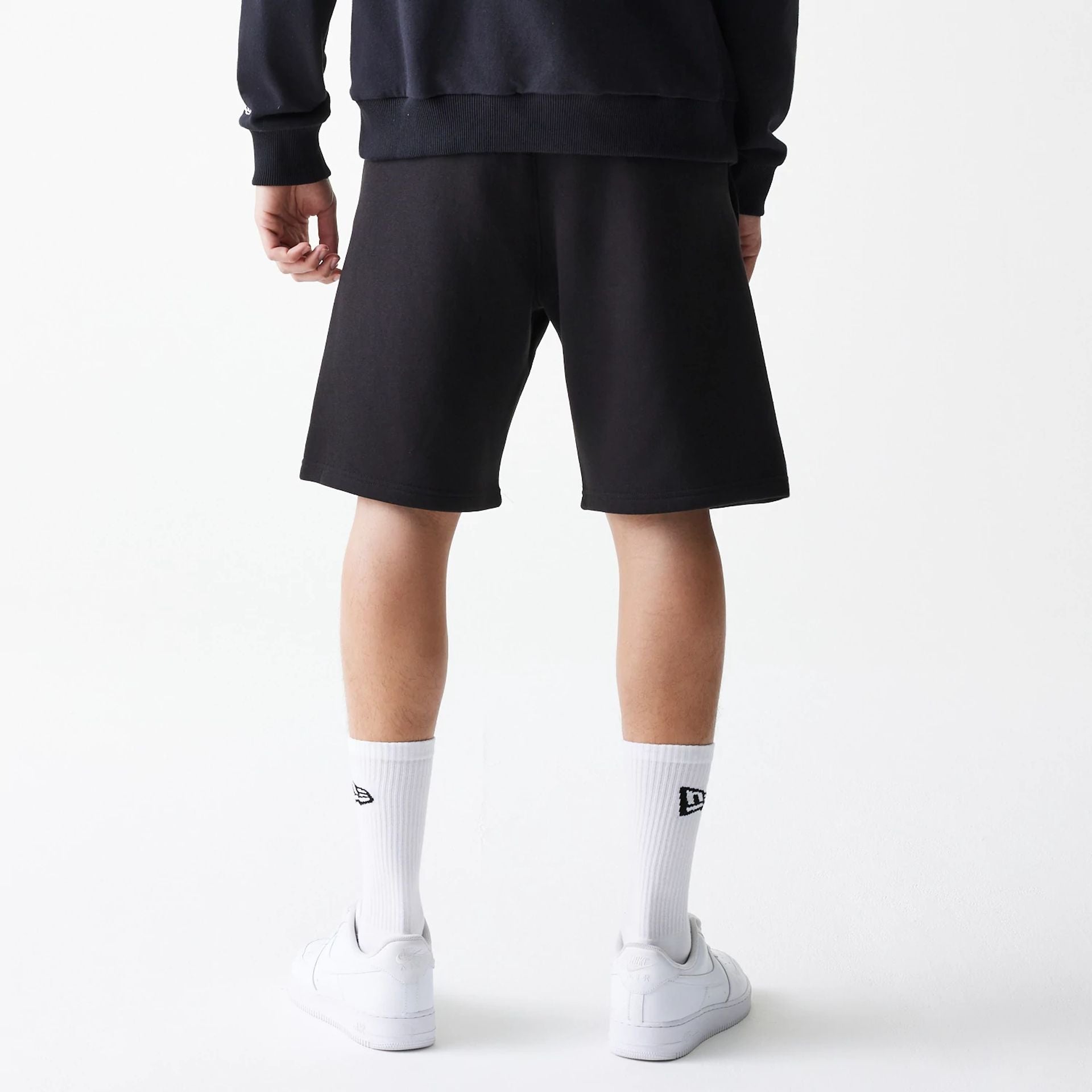 The Male model is wearing New Era Black Oversized One Panel Shorts 2