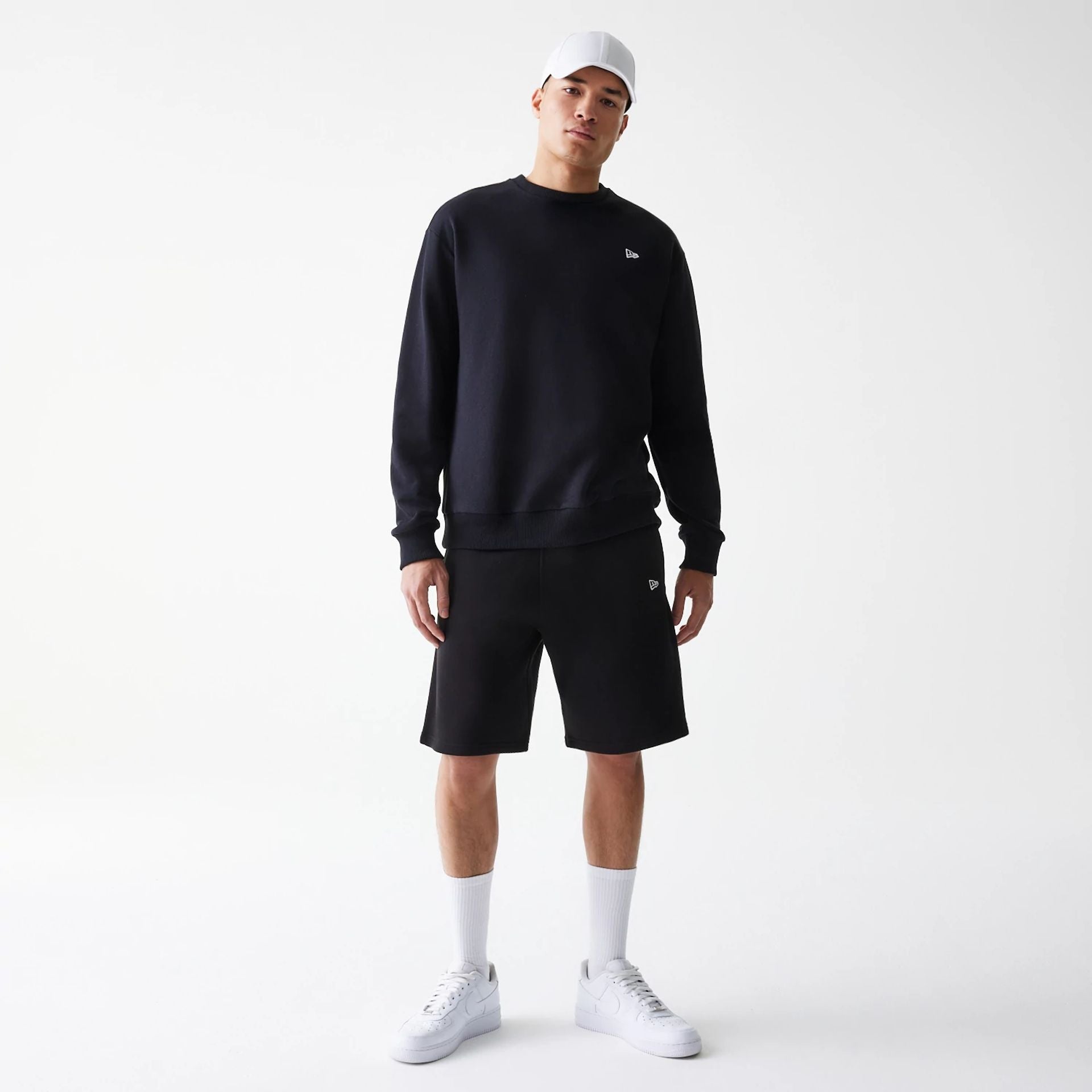 The Male model is wearing New Era Black Oversized One Panel Shorts 8