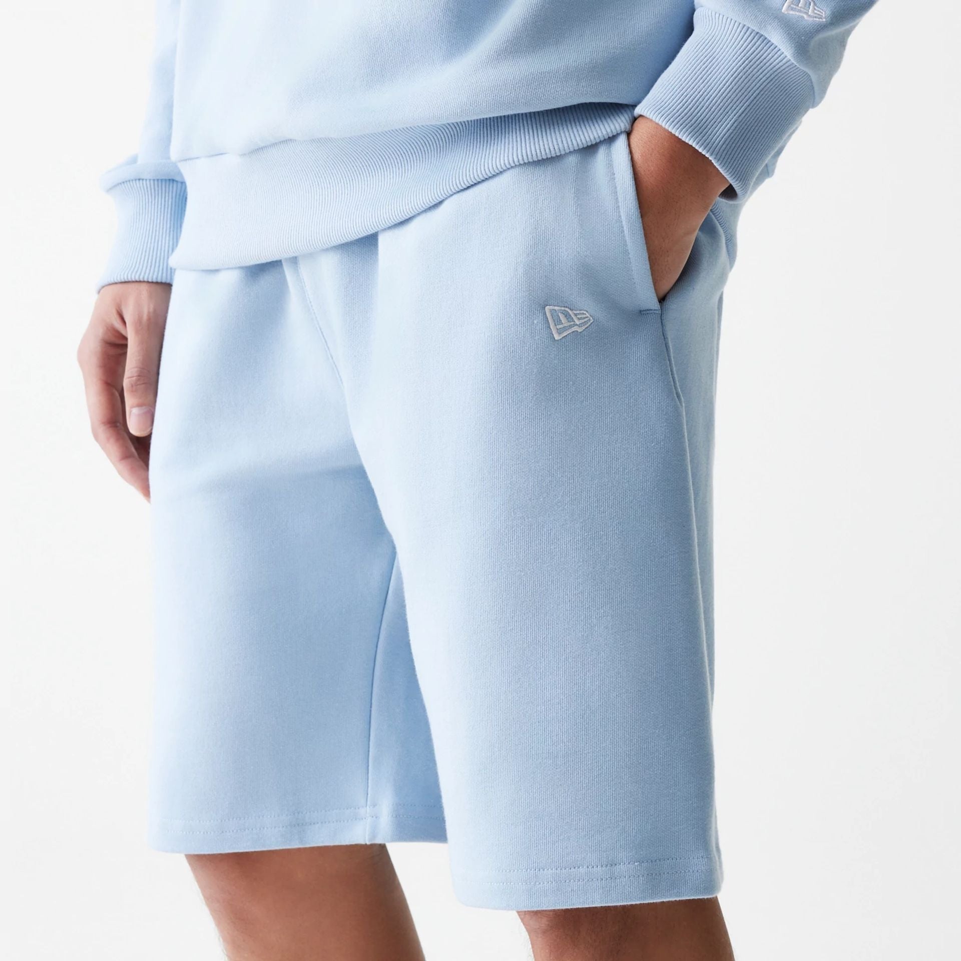 The Male model is wearing New Era Pastel Blue Oversized One Panel Shorts 5