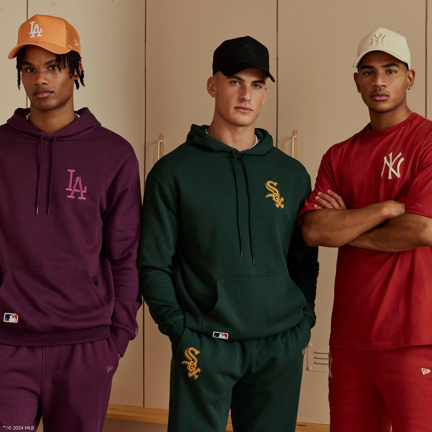 three men wearing matching baseball tracksuits in red, purple and green