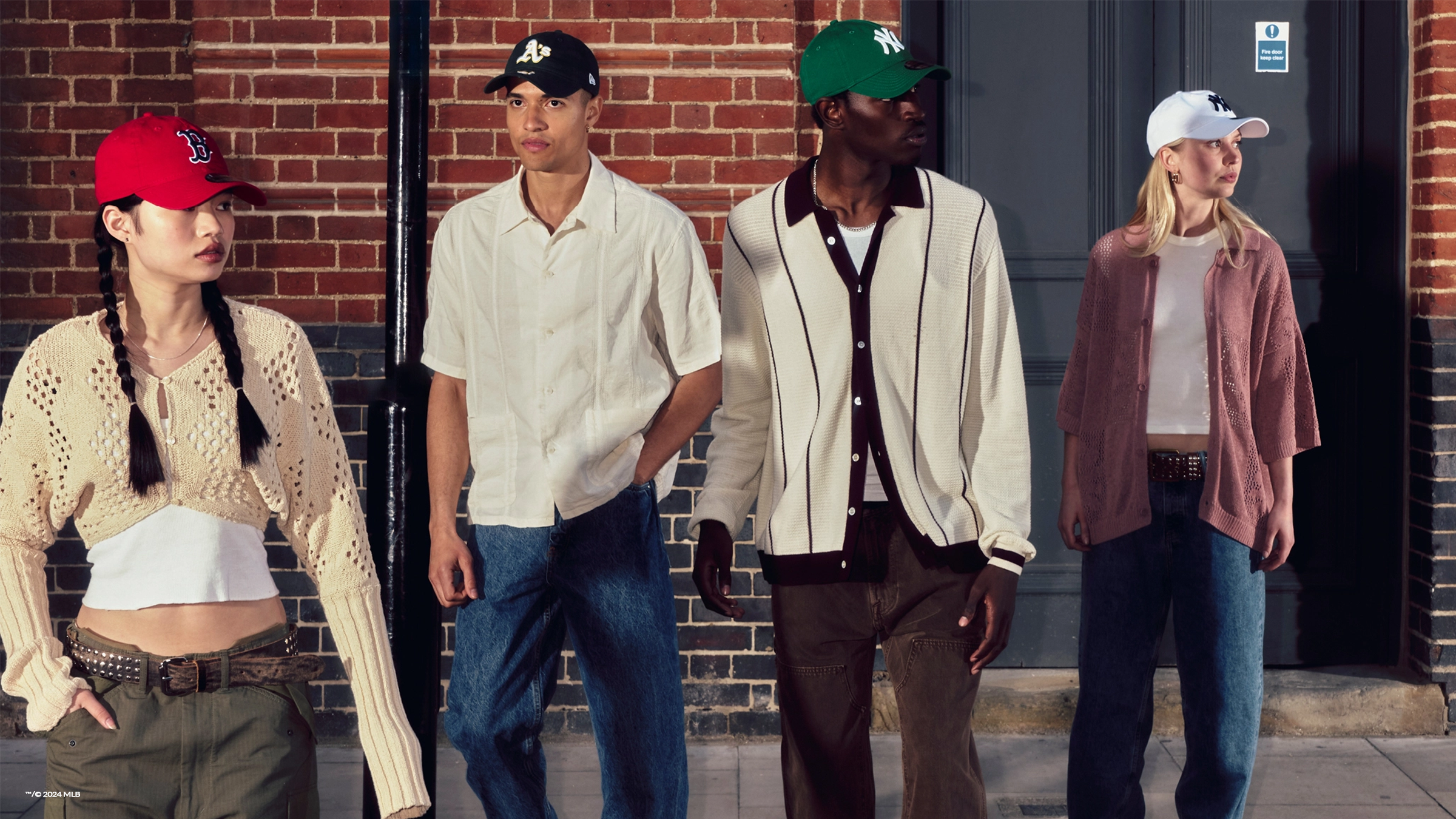 group of young adults on the street wearing new era headwear