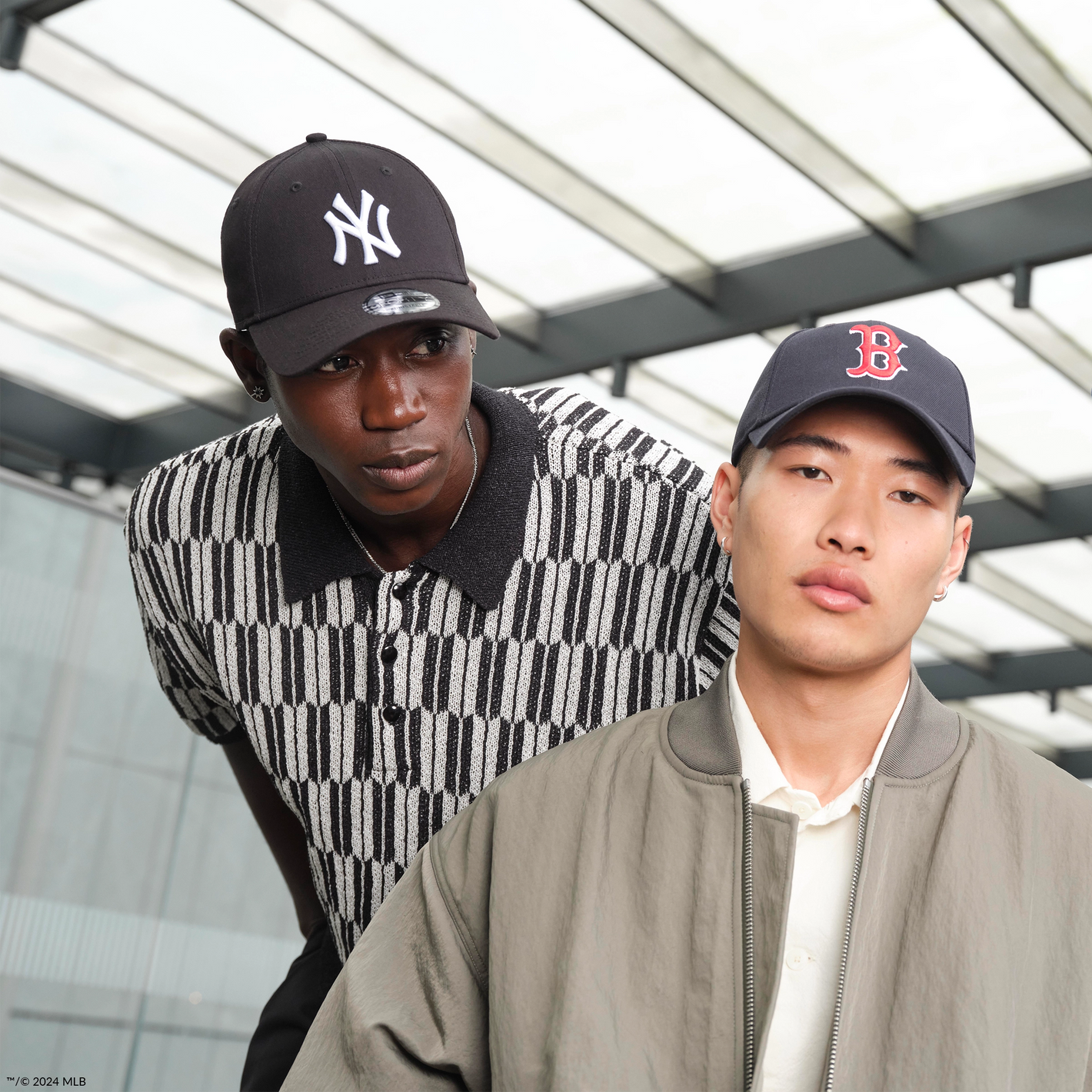 two men wearing new era mlb caps, one with a new york yankees logo and one with a boston red sox logo