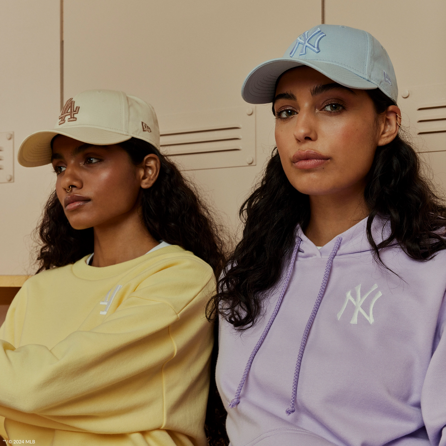 two women wearing a yellow and blue new york yankees and la dodger cap